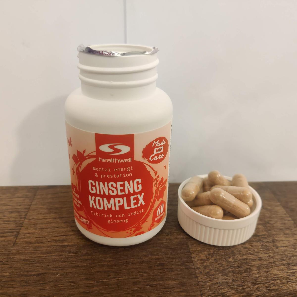 Healthwell Ginseng Komplex på träbord med kapslar bredvid egen testbild