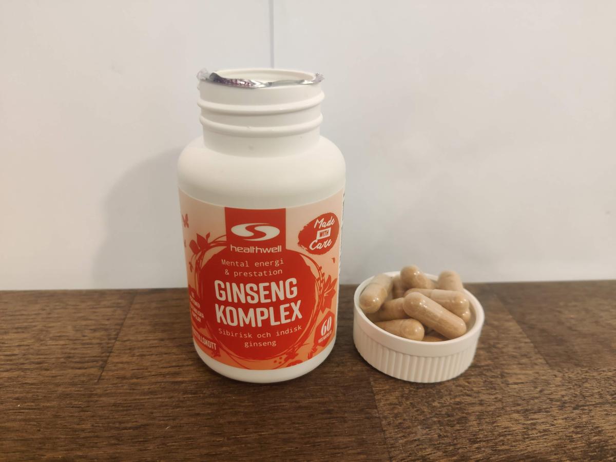 Healthwell Ginseng Komplex på träbord med kapslar bredvid egen testbild