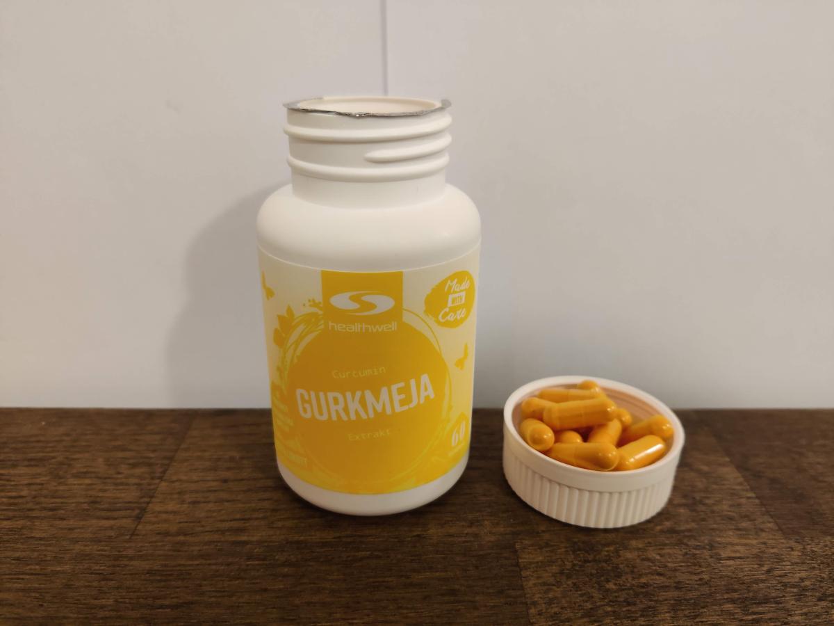 Närbild på Healthwell-burk med några kapslar intill, tagen under testet