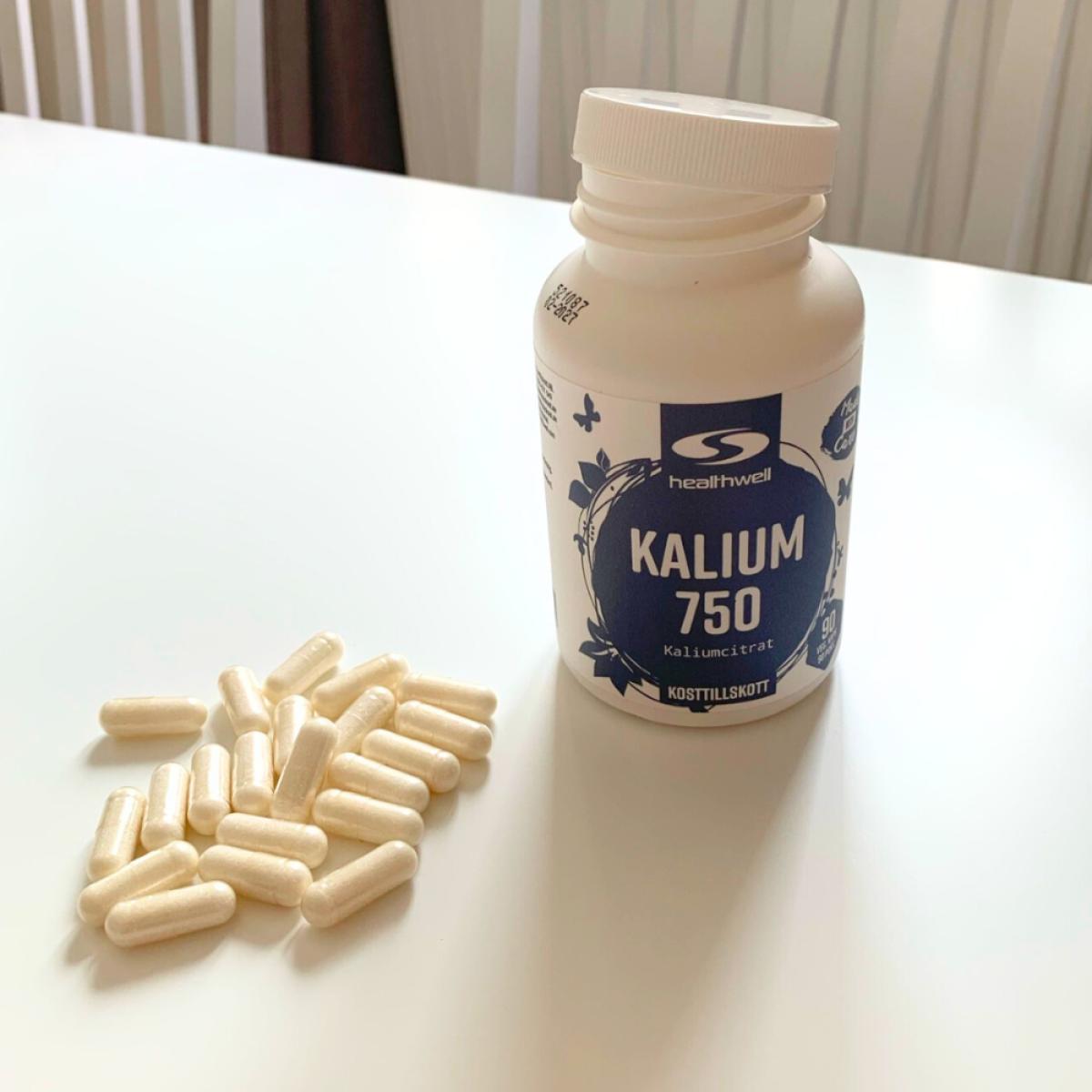Kapslarna från Healthwell Kalium 750 utspridda bredvid burken, fotograferat av oss