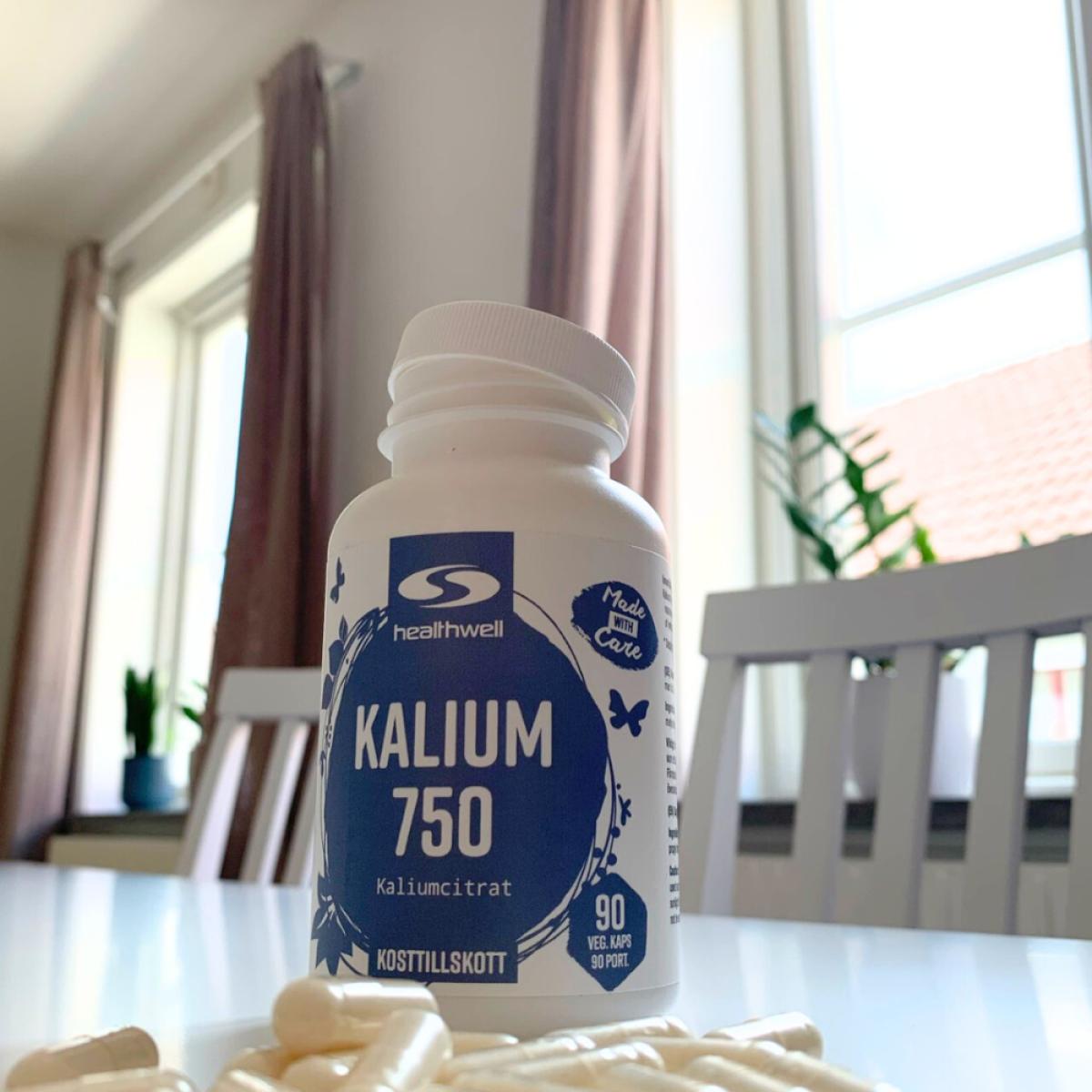 Öppnad burk Healthwell Kalium 750 med kapslar i förgrunden, vår bild