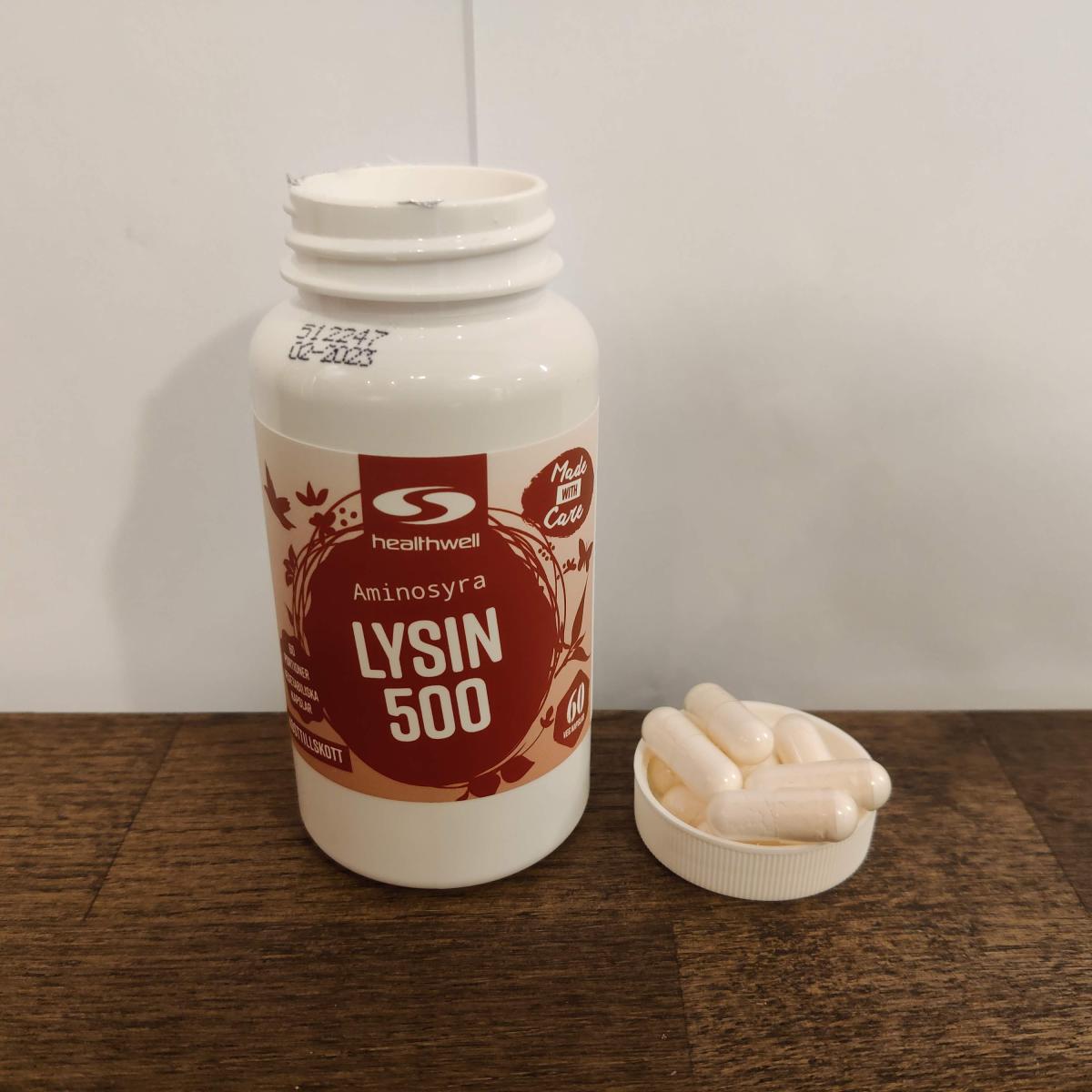 Närbild på Healthwell Lysin 500 med kapslar bredvid, fotograferad av oss