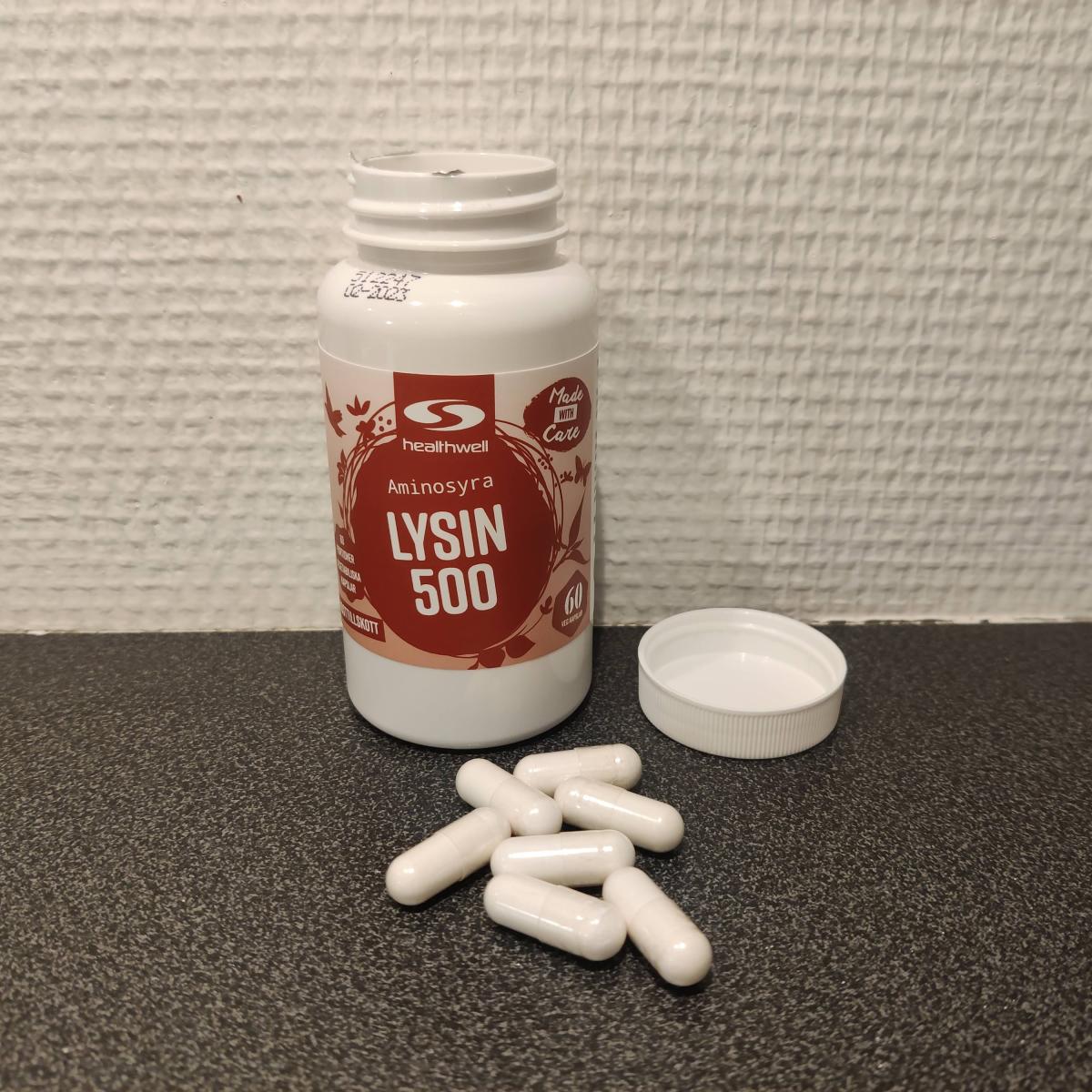Öppnad burk Healthwell Lysin 500 med kapslar på bänken, egen testbild