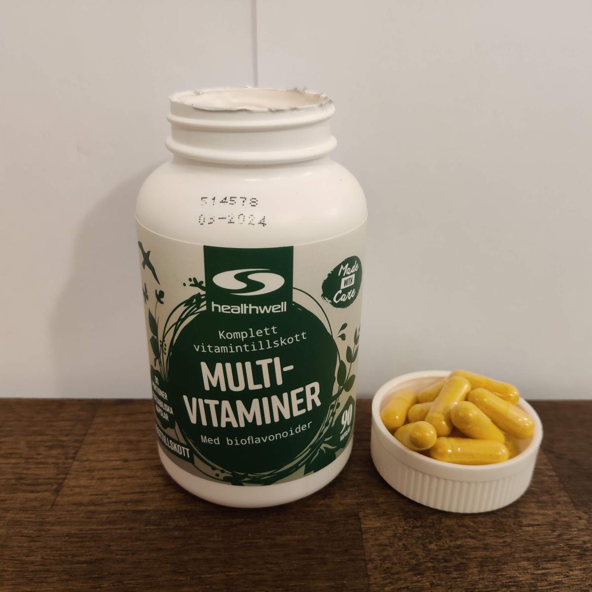 Närbild på Healthwell MultiVitaminer med flera kapslar bredvid taget av oss