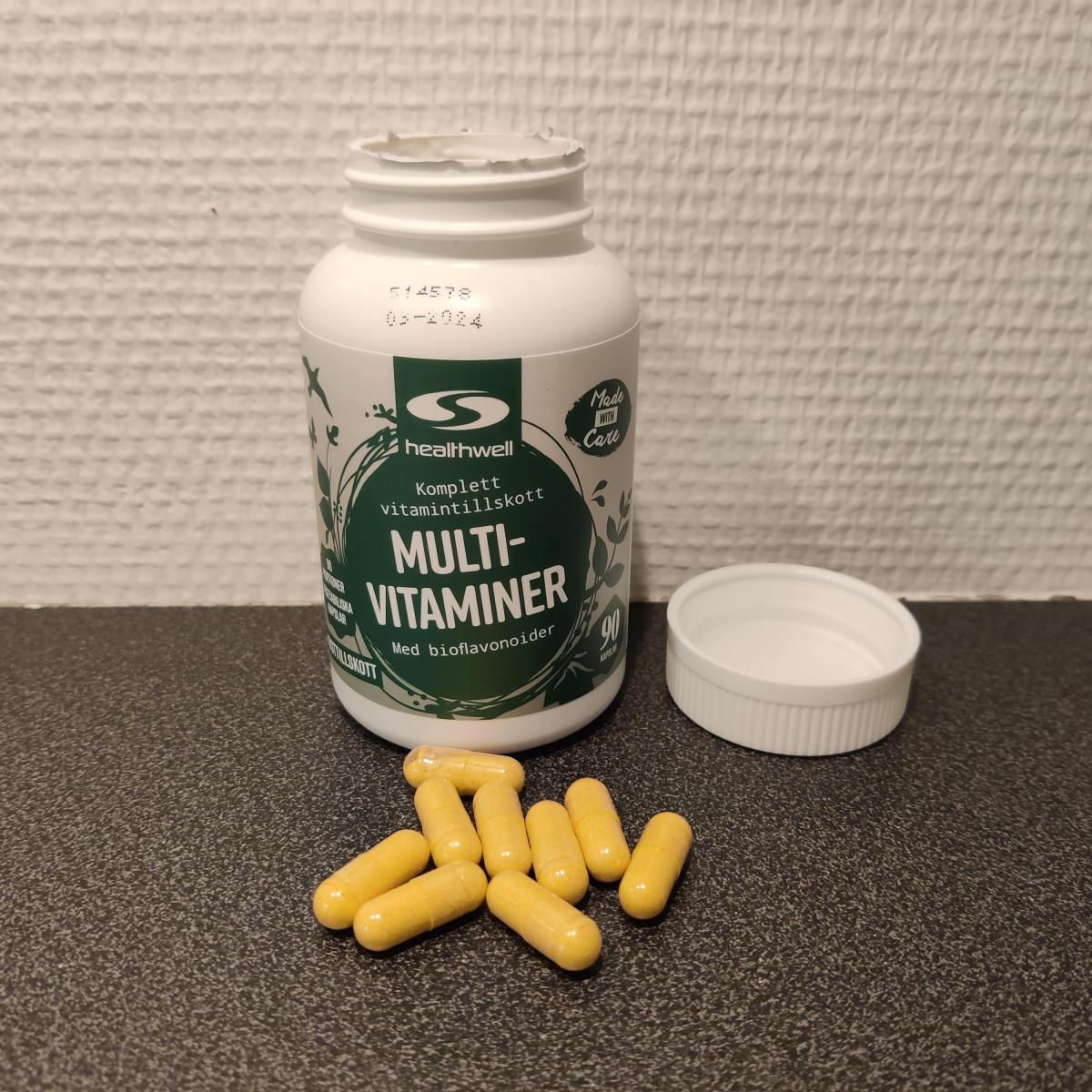 Öppnad burk Healthwell MultiVitaminer med kapslar på bänken foto taget av oss