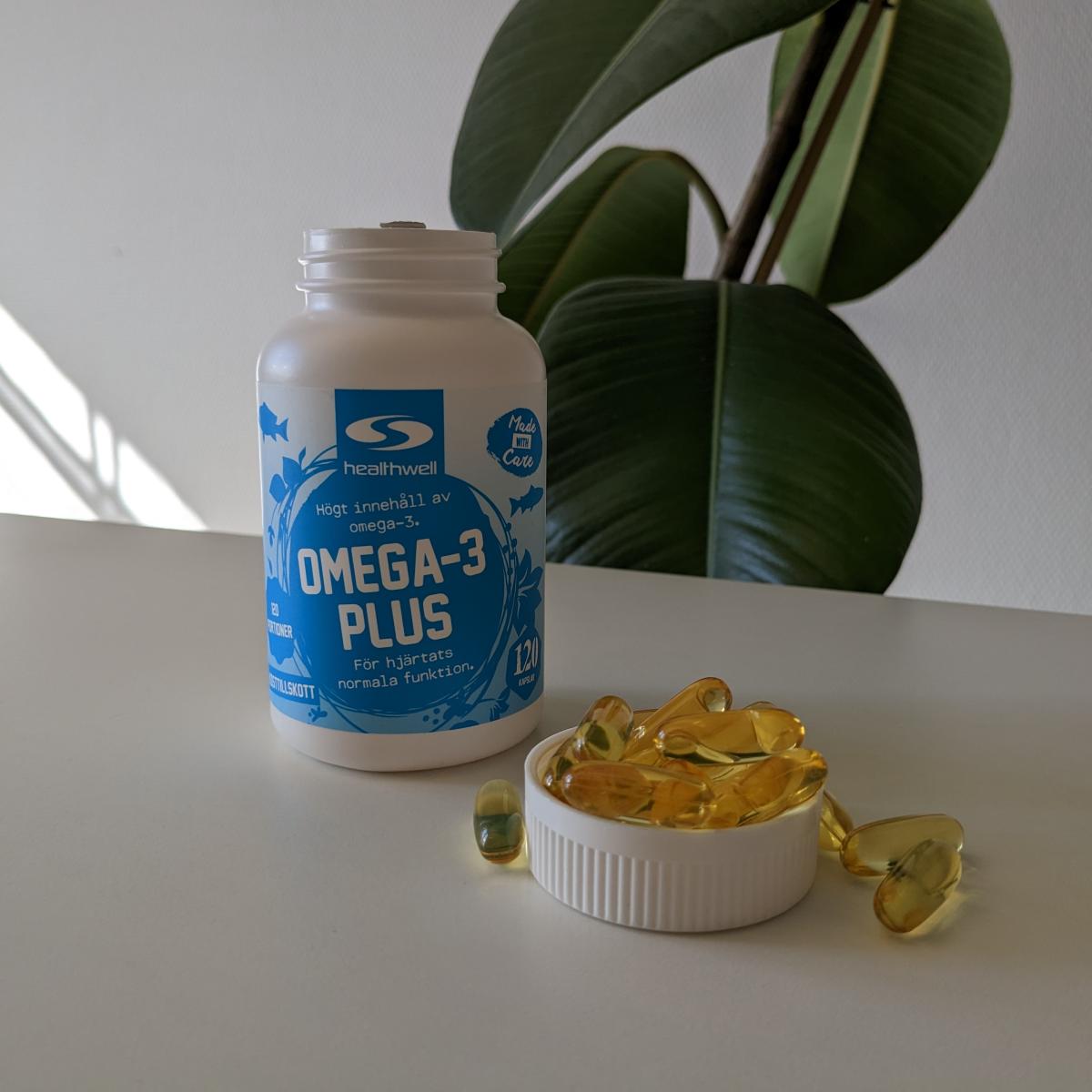 Healthwell Omega-3 Plus i dagsljus med kapslar på bordet, foto taget av oss under testet