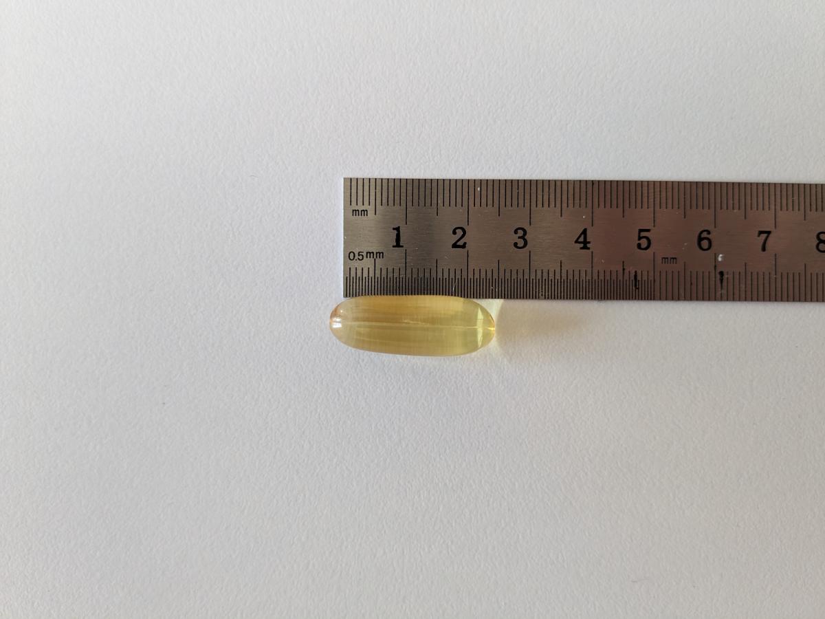 Kapsel från Healthwell Omega-3 Plus bredvid linjal cirka 23 mm, fotad under vårt test