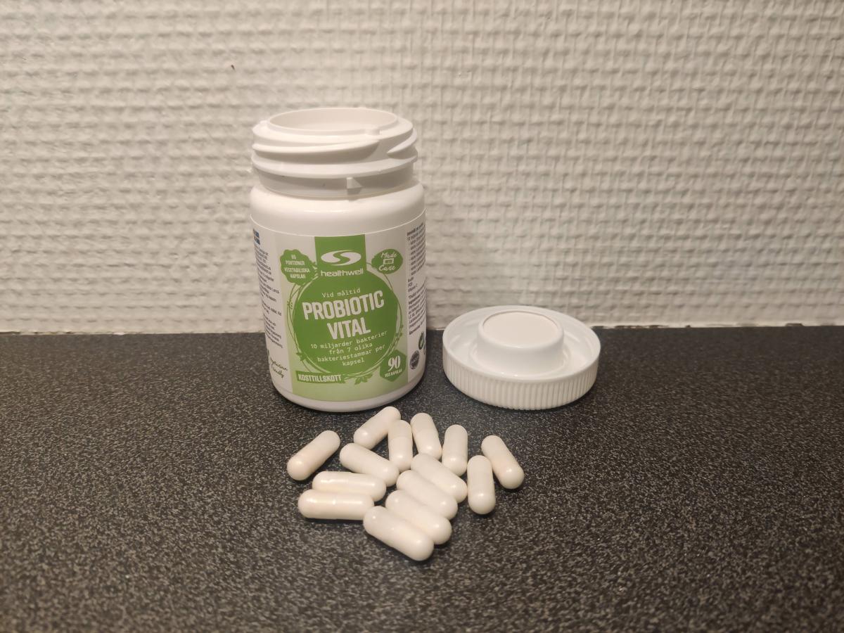 Healthwell Probiotic Vital med öppnad burk och kapslar på bänkskiva, foto taget av oss under testet