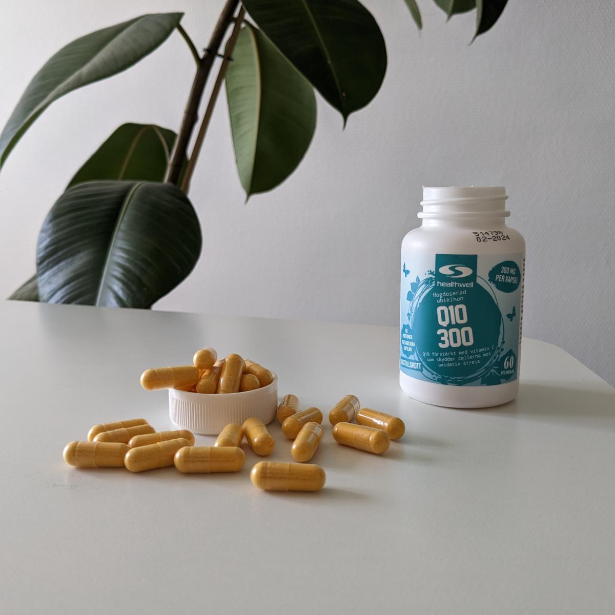 Öppnad burk Healthwell Q10 300 med kapslar utlagda på bordet, egen bild från vår testperiod