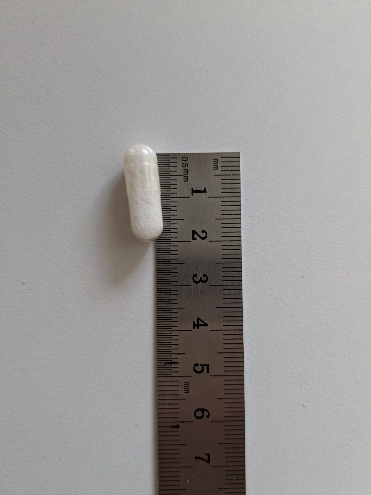 Healthwell Selen kapsel bredvid linjal visar kompakt storlek cirka 2 cm