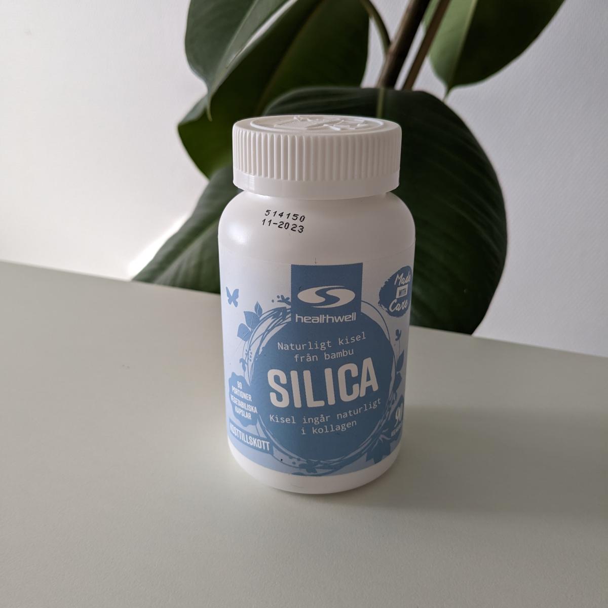 Öppen burk Healthwell Silica och kapslar på bordet, vårt testfoto