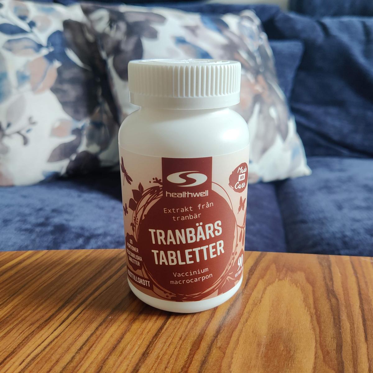 Öppen burk med rosa tranbärstabletter på bänkskiva, foto från vårt test