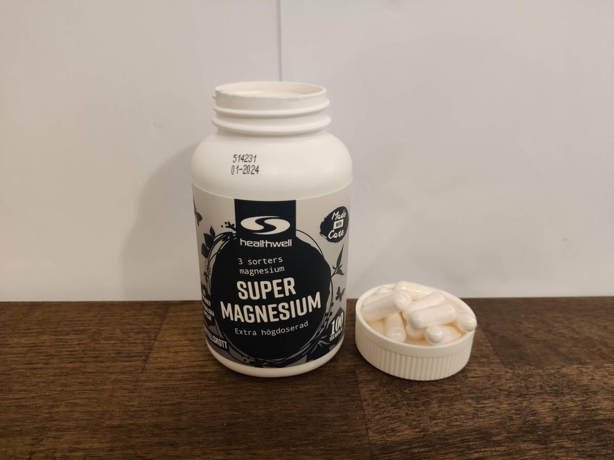 Healthwell Trippel Magnesium i vardagsljus med kapslar bredvid, taget av oss