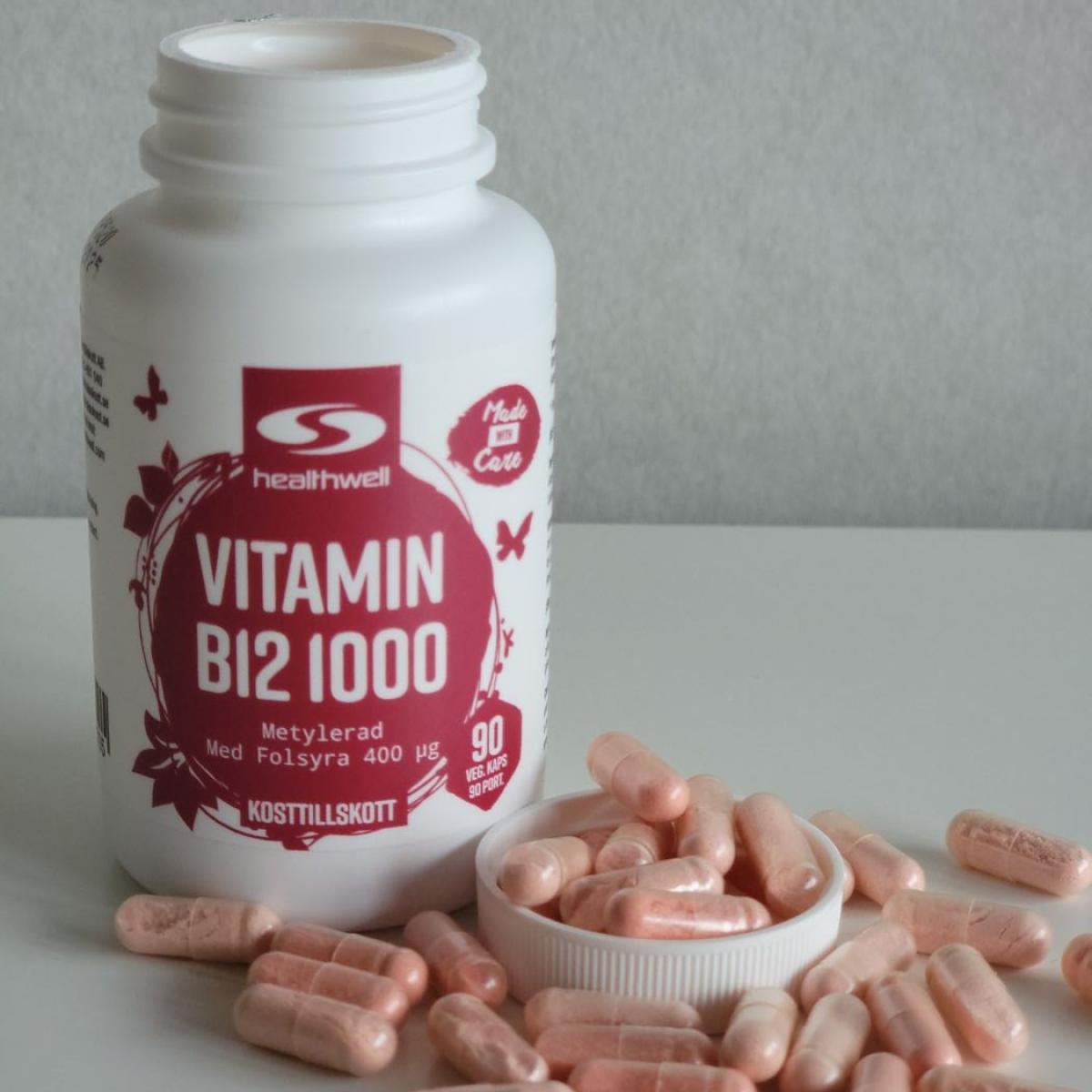 Egen bild av Healthwell Vitamin B12 1000, öppnad burk med rosatonade vegokapslar på bordet under vårt test