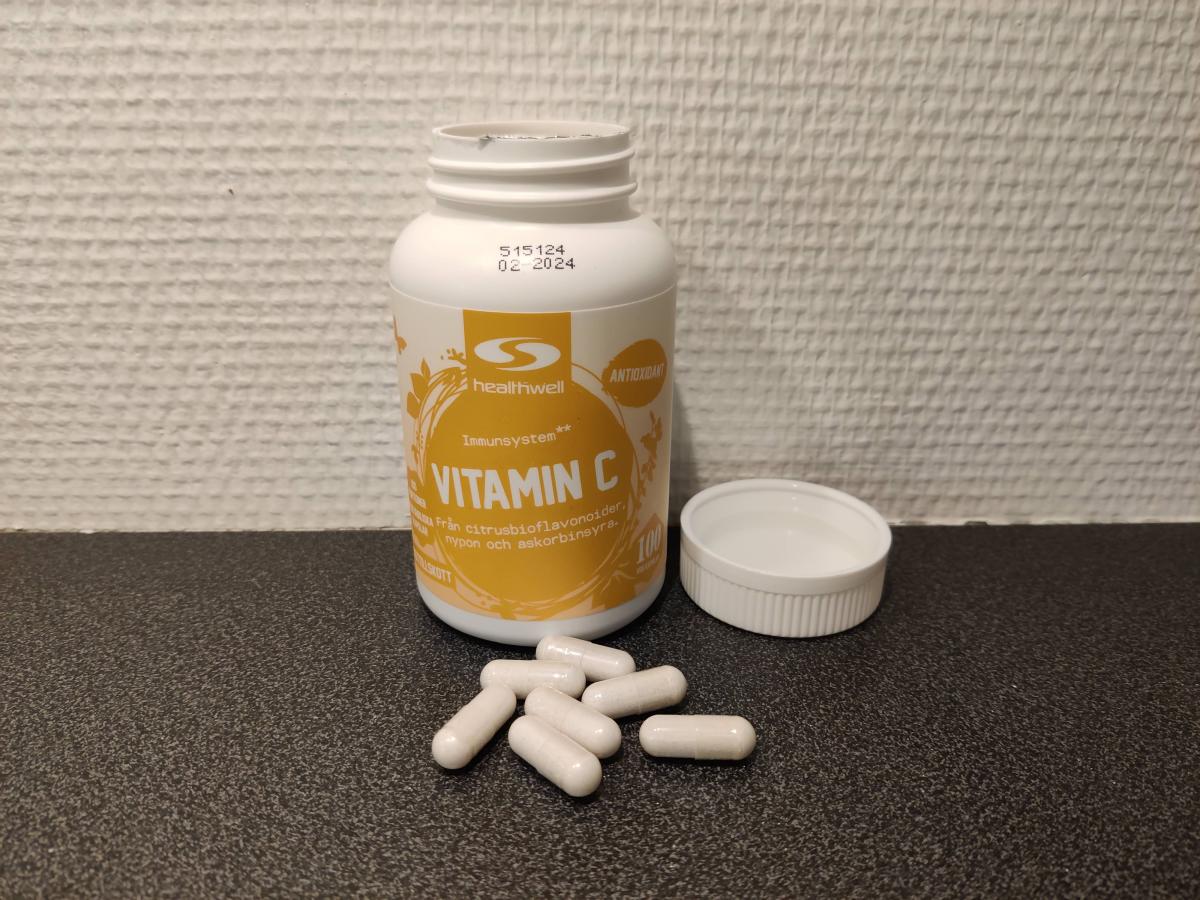 Healthwell Vitamin C öppnad burk med kapslar på bänken foto taget av oss