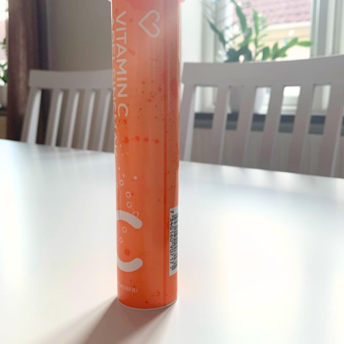 Upplöst C-vitamin i klart pärlande glas bredvid röret, fotograferat av oss