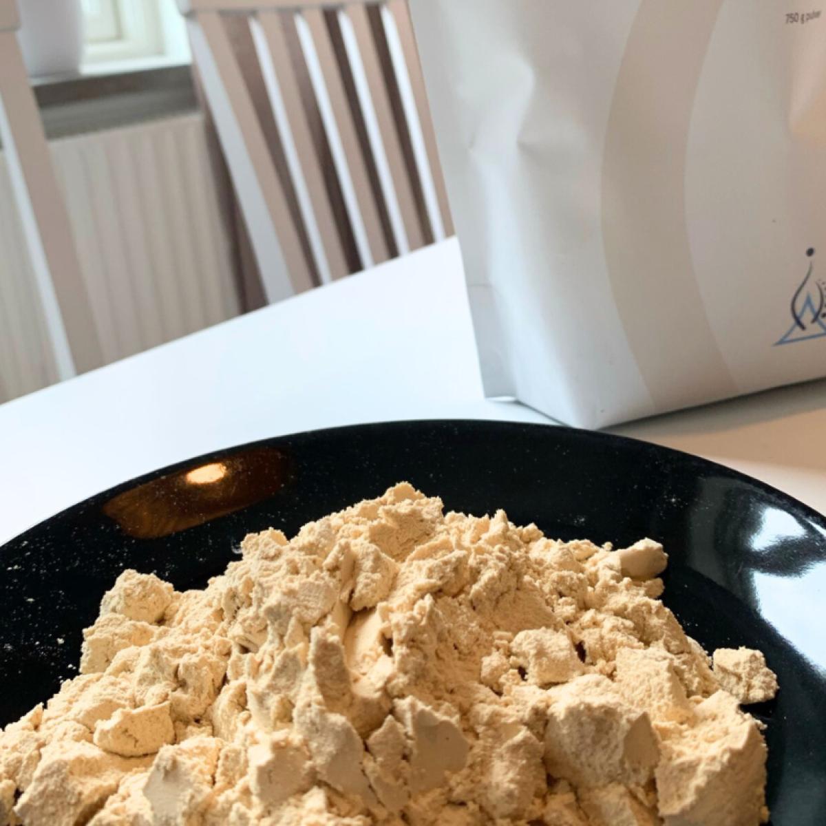 Ljust finmalet ärtprotein upplagt på tallrik med påsen i bakgrunden egen bild