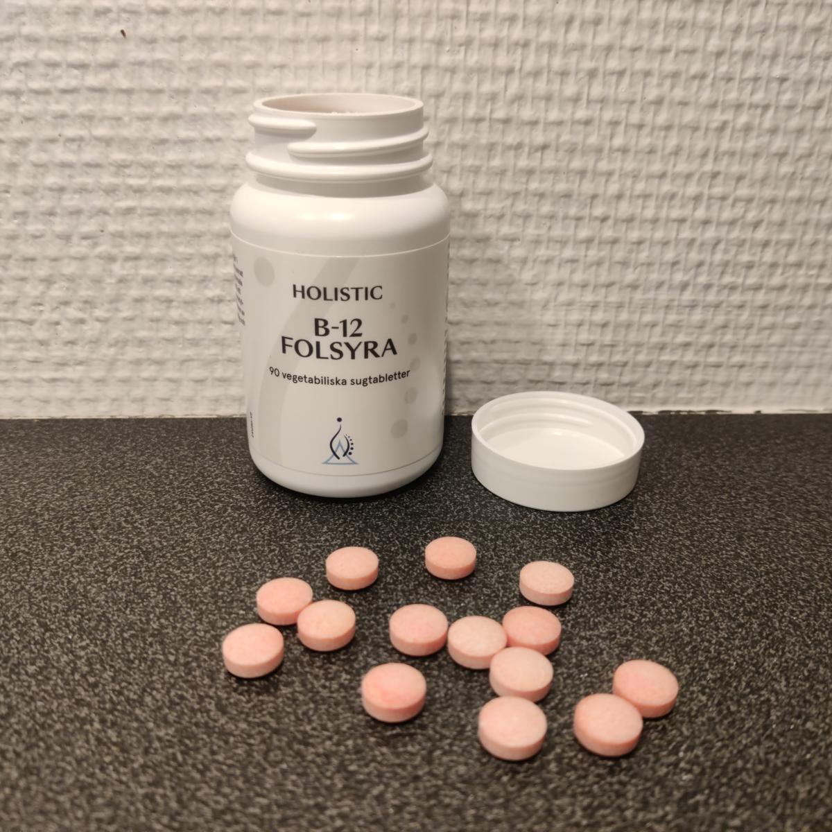Holistic B12 Folsyra öppnad burk med rosa sugtabletter på bänkskiva foto av oss