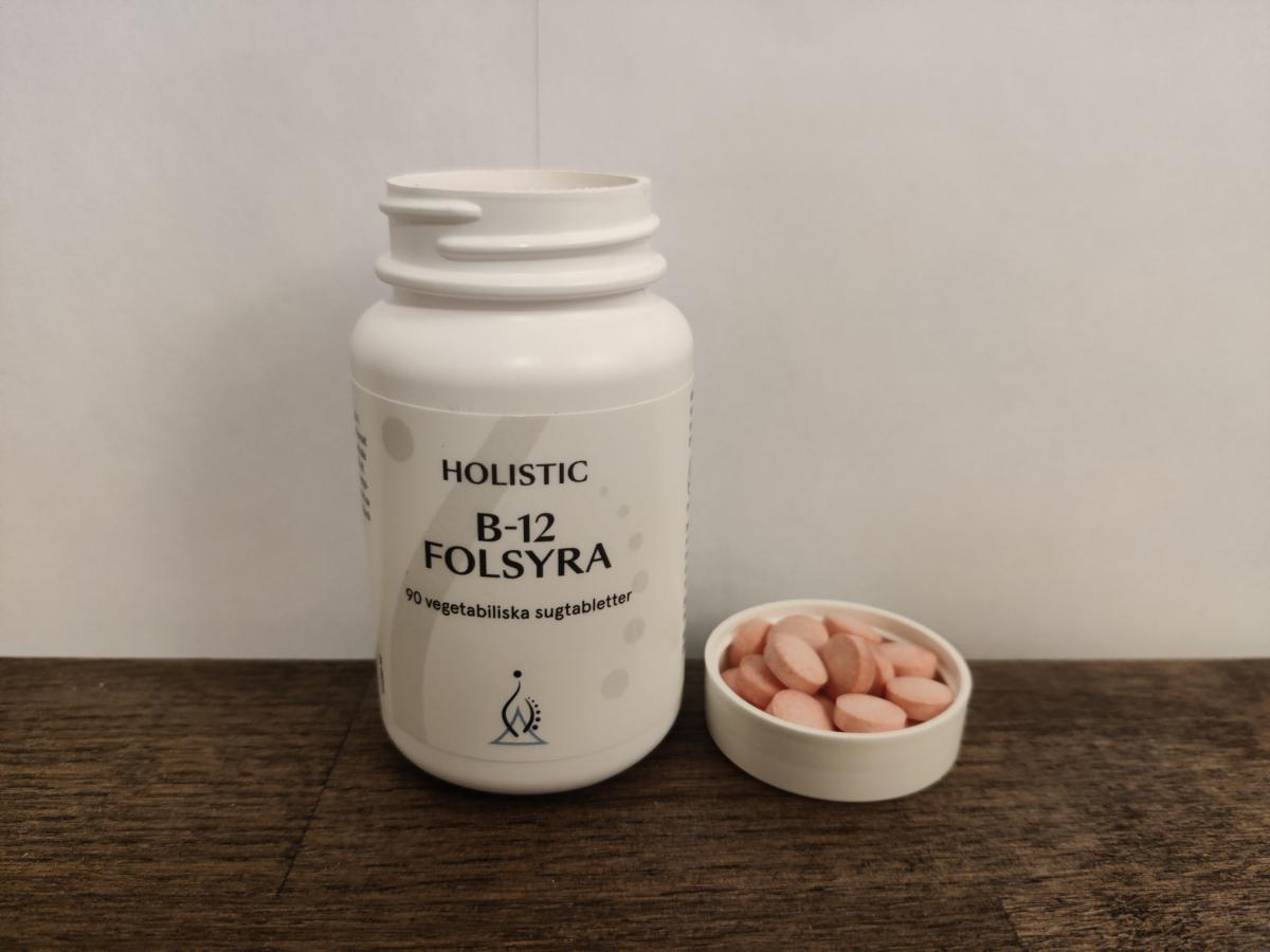 Holistic B12 Folsyra på träbord med tabletter bredvid eget foto