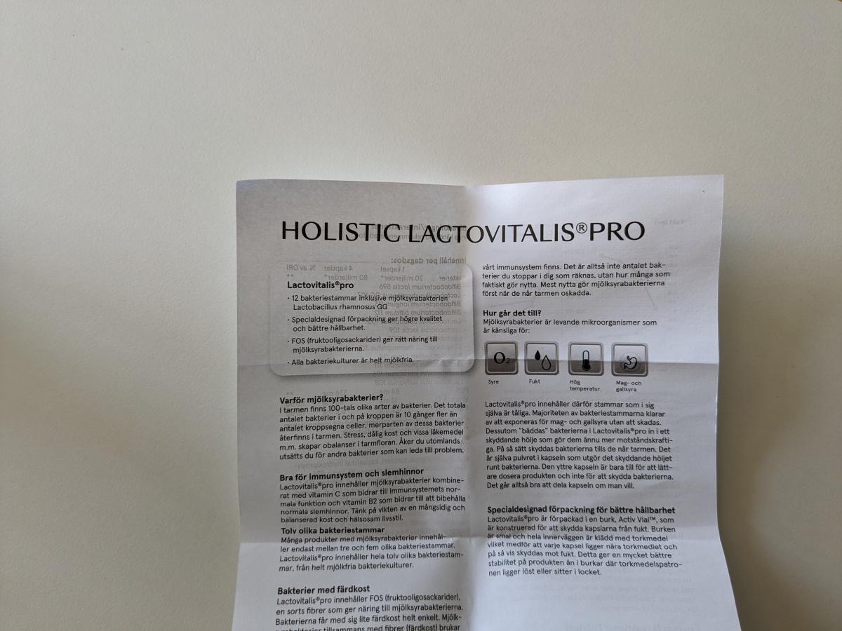 Informationsbladet till Holistic LactoVitalis Pro med text om 12 stammar, FOS och skyddande förpackning, fotat av oss