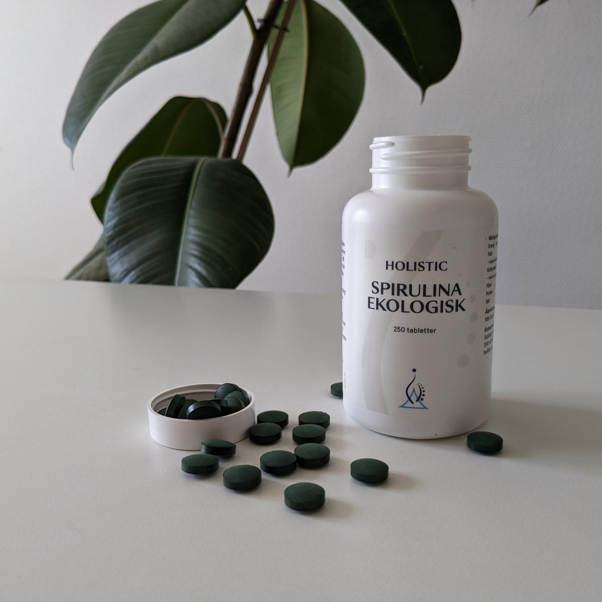Spirulinatabletter uppifrån med öppnad flaska och lock, eget foto från testet