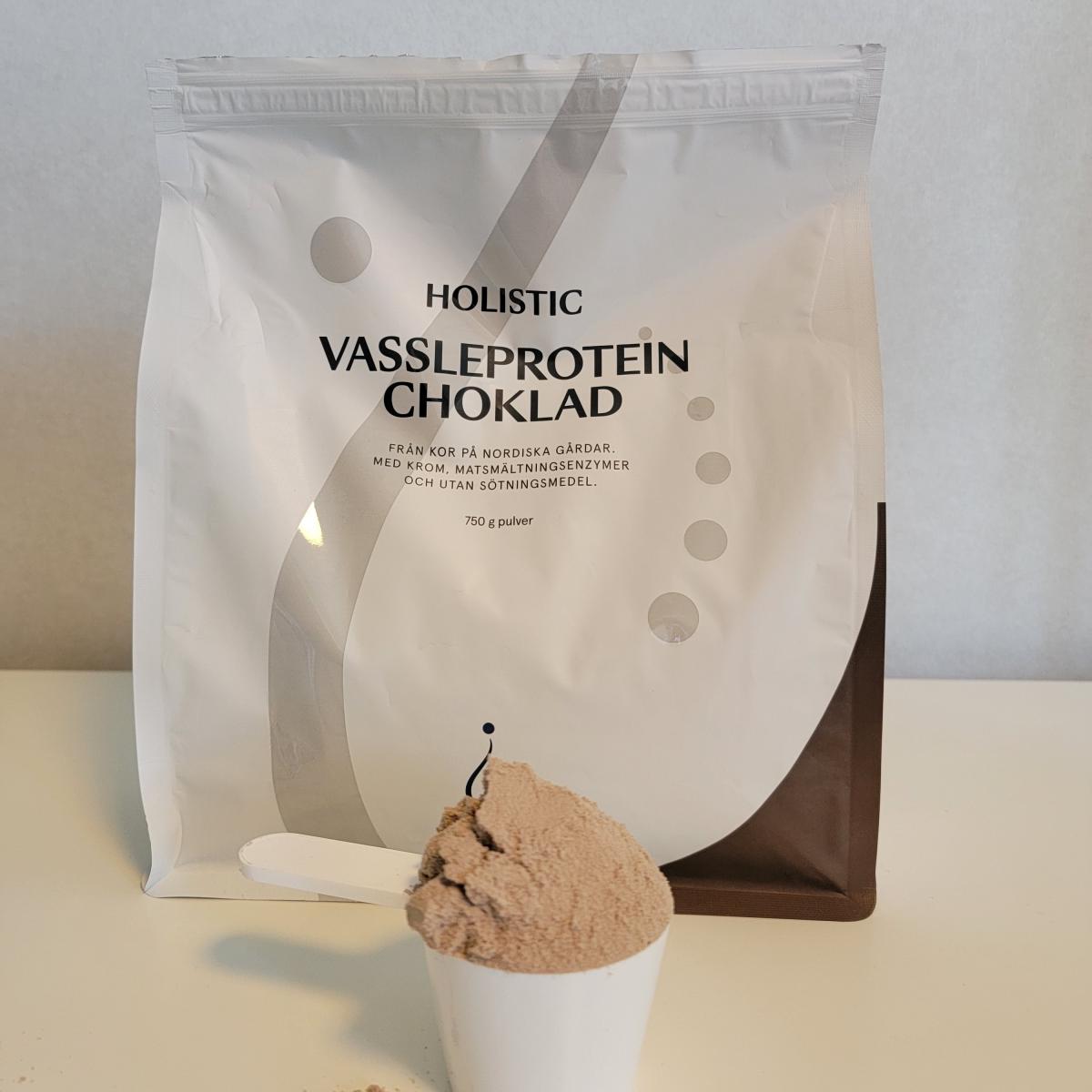 Holistic Vassleprotein choklad fotograferad av oss under testet, med skopa fylld av luftigt pulver