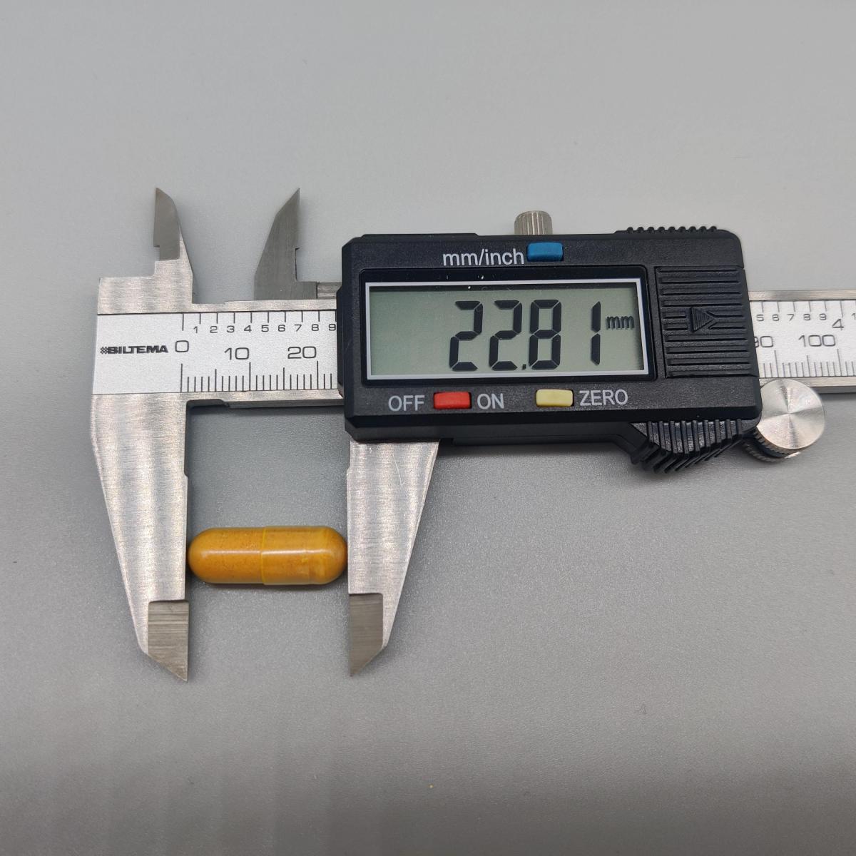 Mätning av kapsel från Inflamin Premium med skjutmått 22,81 mm, fotad av oss