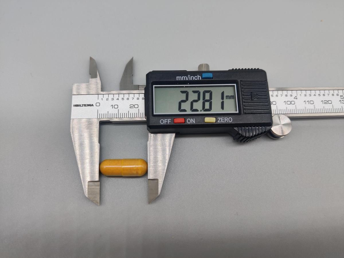 Mätning av kapsel från Inflamin Premium med skjutmått 22,81 mm, fotad av oss