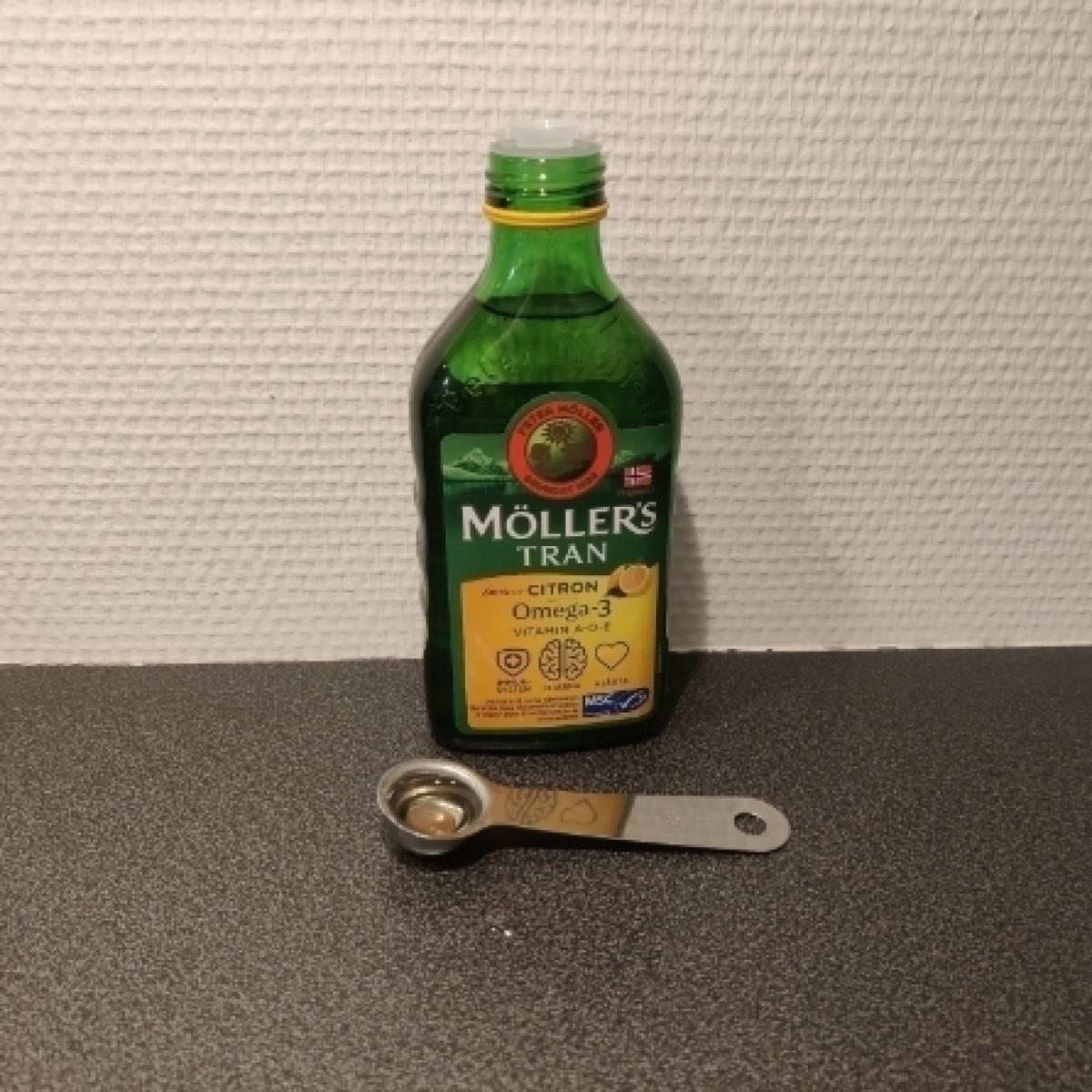 Möllers Tran upphälld på vitt fat ljus och klar olja