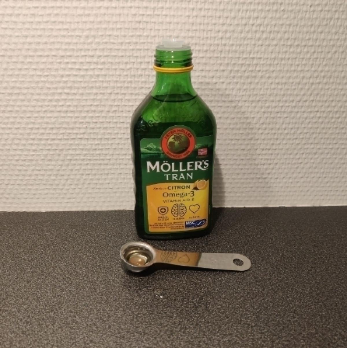 Möllers Tran citron i glasflaska med måttsked foto taget av oss under testet