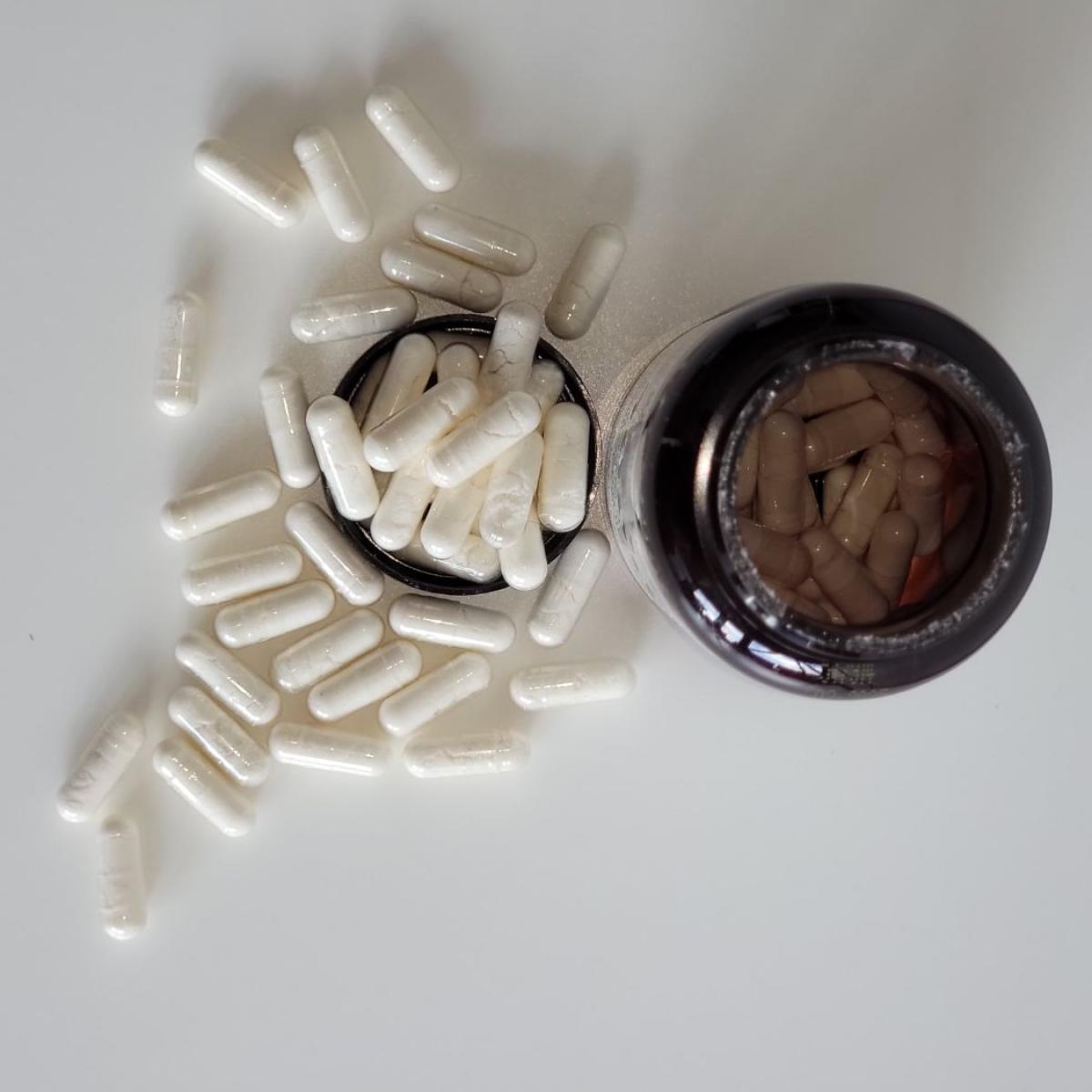 Top-down vy av Närokällan D3 5000 Vegan med spridda kapslar och öppen flaska, fotograferad av oss