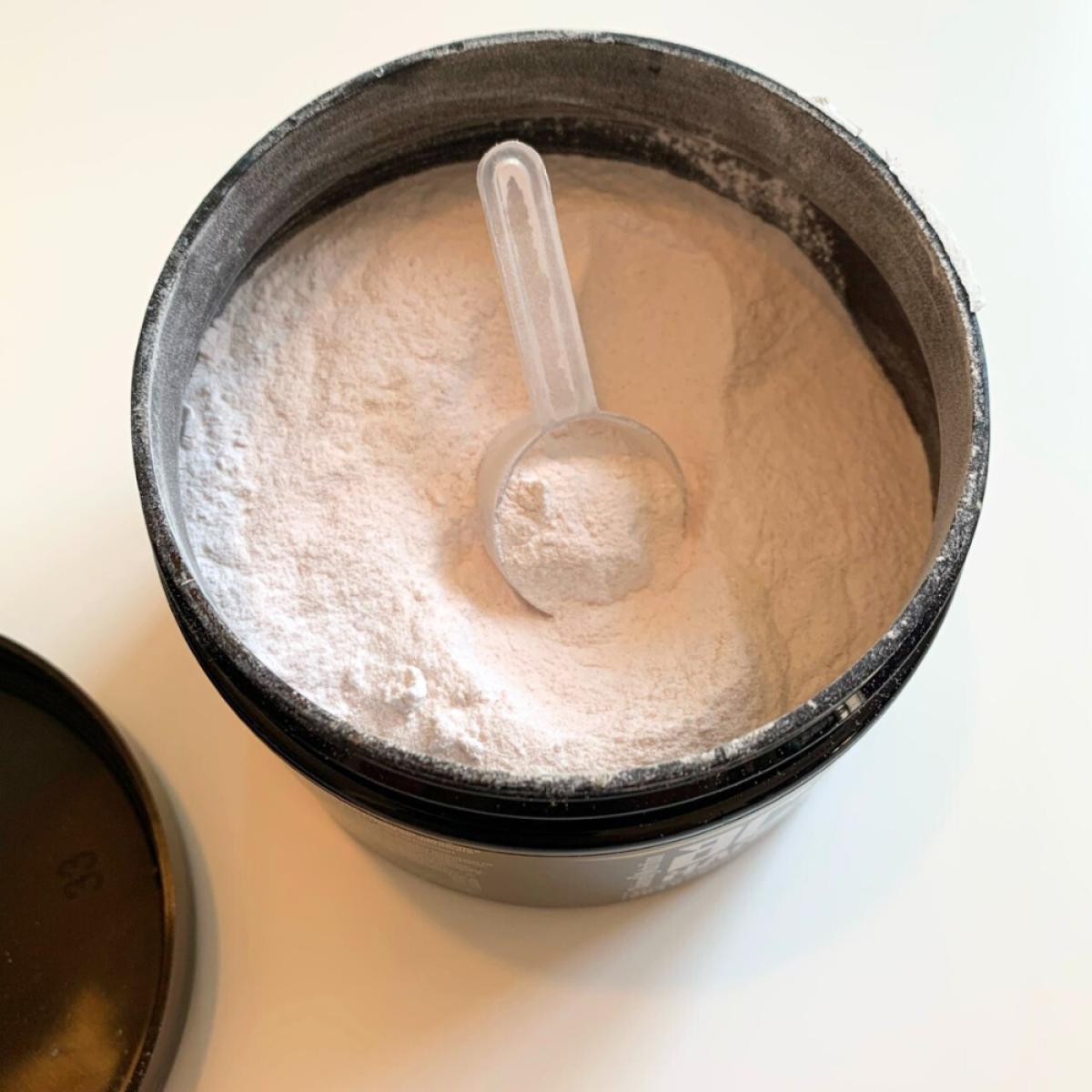 Öppen burk med vitrosa pulver och skopa av BCAA Hardcore, vår testbild