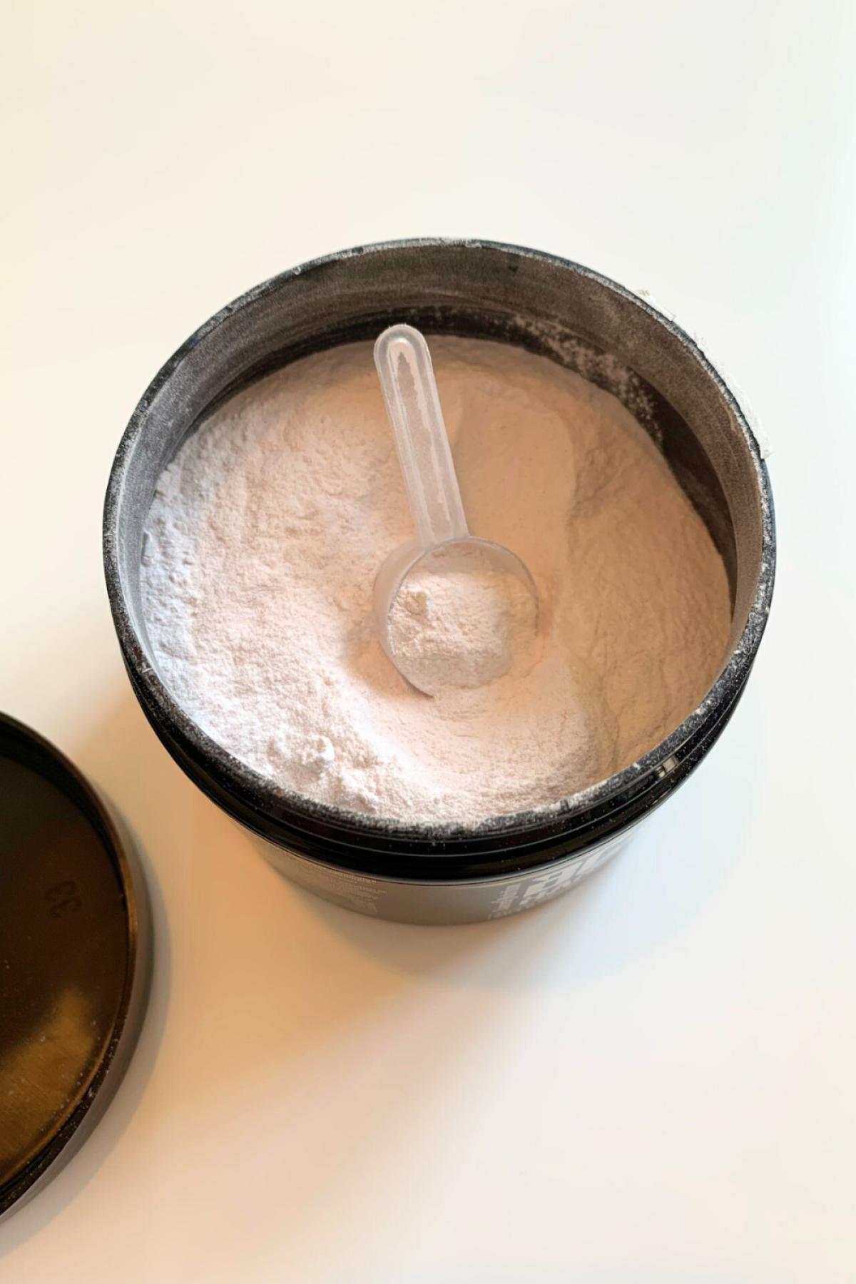 Öppen burk med vitrosa pulver och skopa av BCAA Hardcore, vår testbild