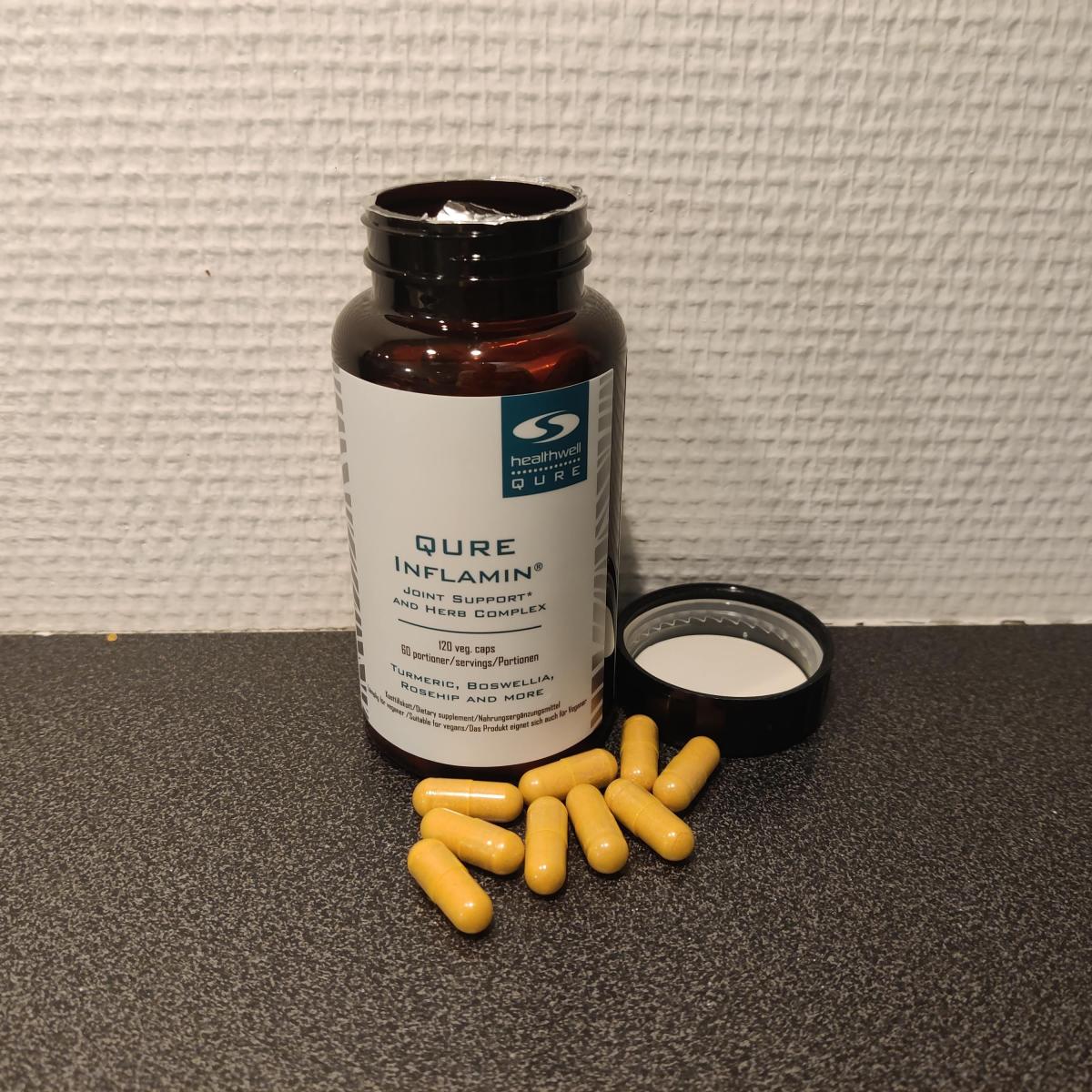 Öppen burk med Inflamin Premium och kapslar på köksbänken, fotad av oss