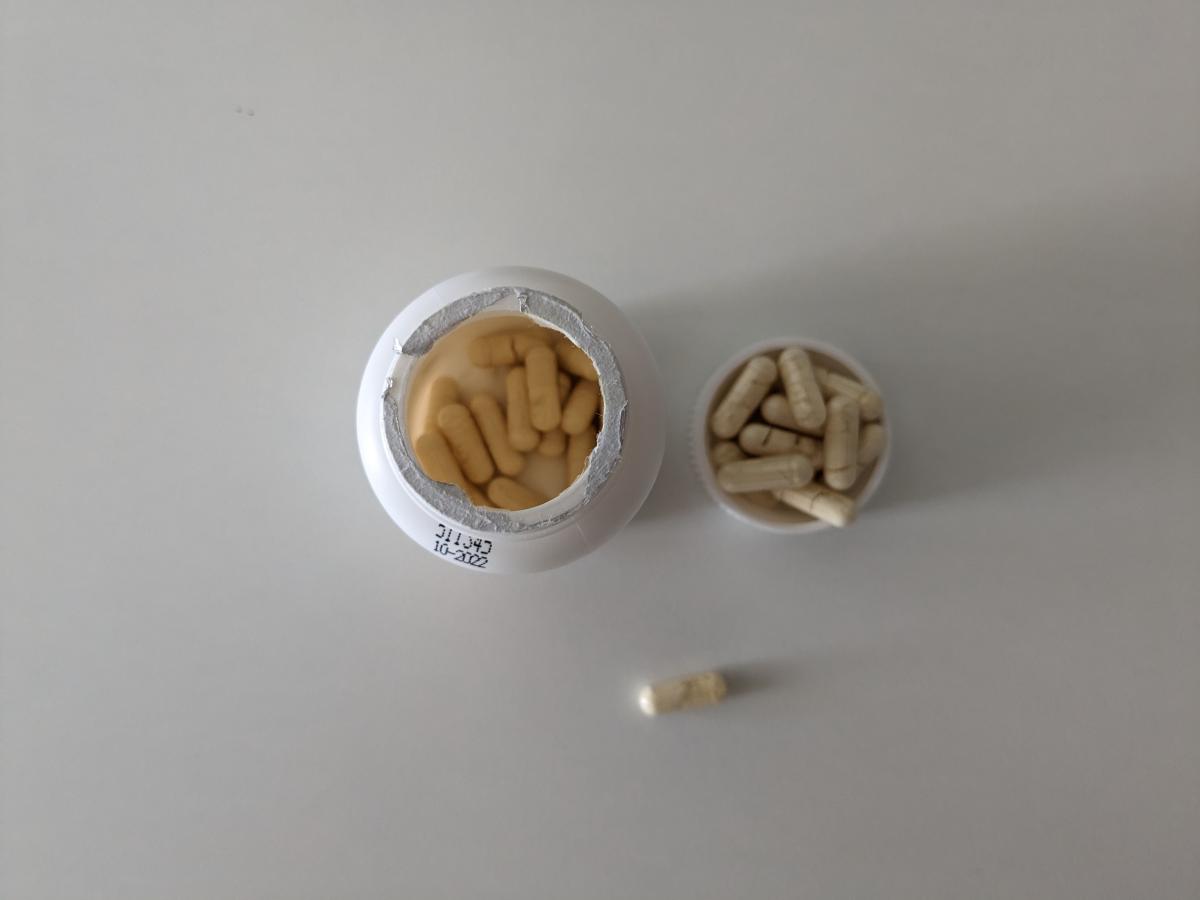 Ovanifrånbild tagen av oss av öppnad burk med foliesigill och kapslar bredvid