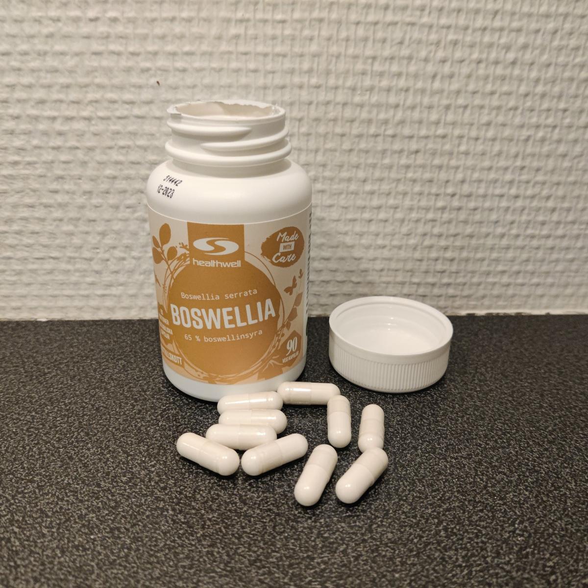 Öppnad burk och utspridda kapslar av Healthwell Boswellia i köksljus, foto taget av oss