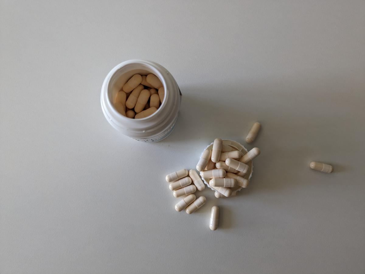 Öppen burk Pharma Nord Glukosamin sedd ovanifrån med kapslar utspridda, fotograferad av oss