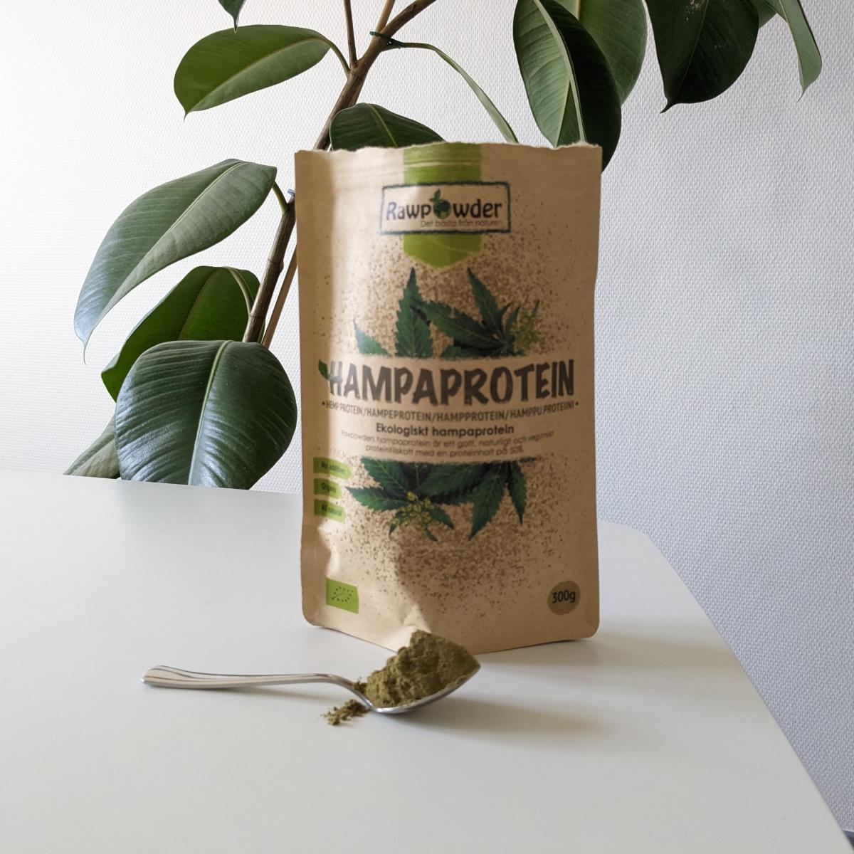 Rawpowder Hampaprotein EKO och en sked pulver på bordet, fotograferat av oss