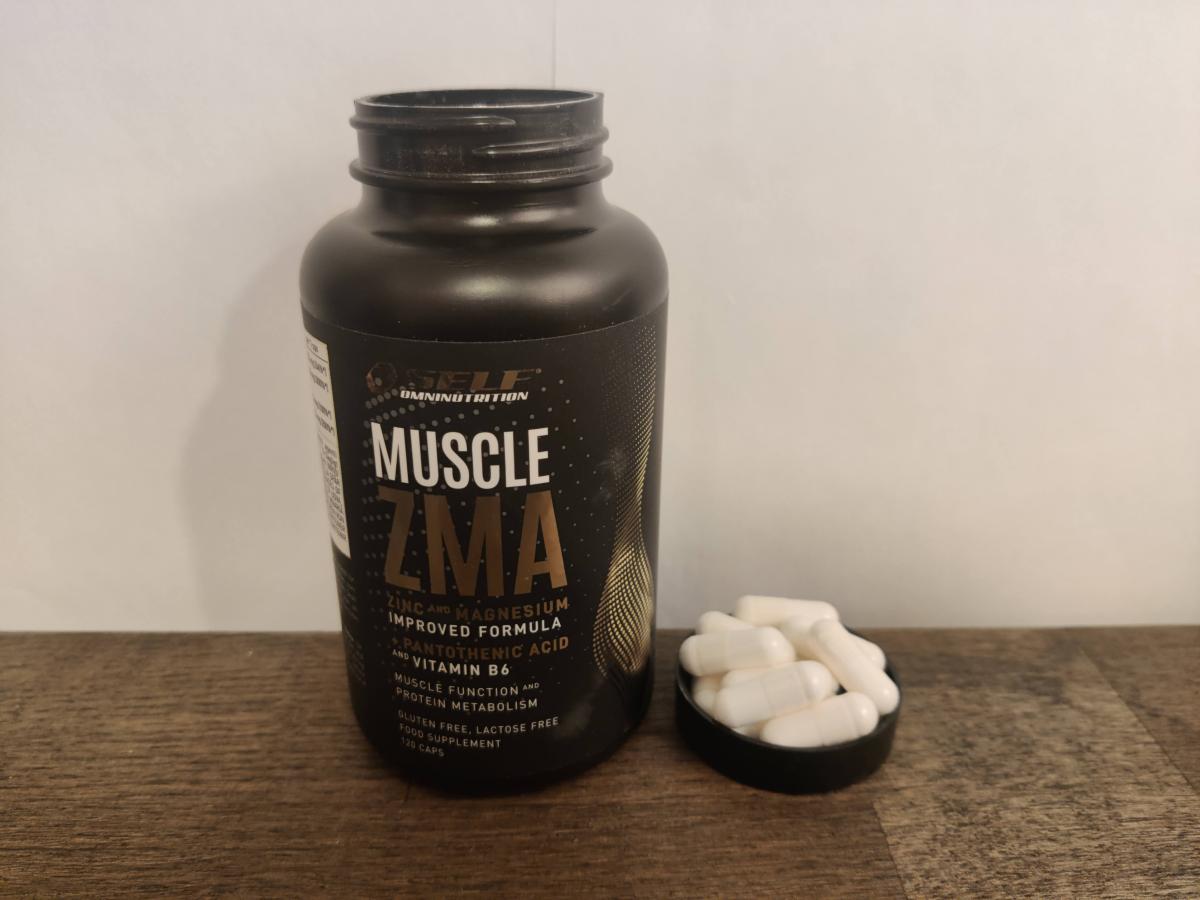 ZMA-burken i närbild med några kapslar bredvid på träbord, vår egen produktbild
