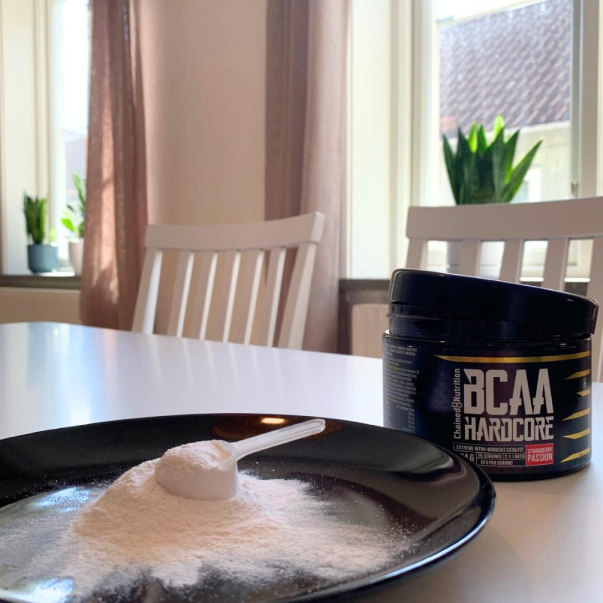 Skopa med BCAA-pulver på tallrik och burken i bakgrunden, foto från testet