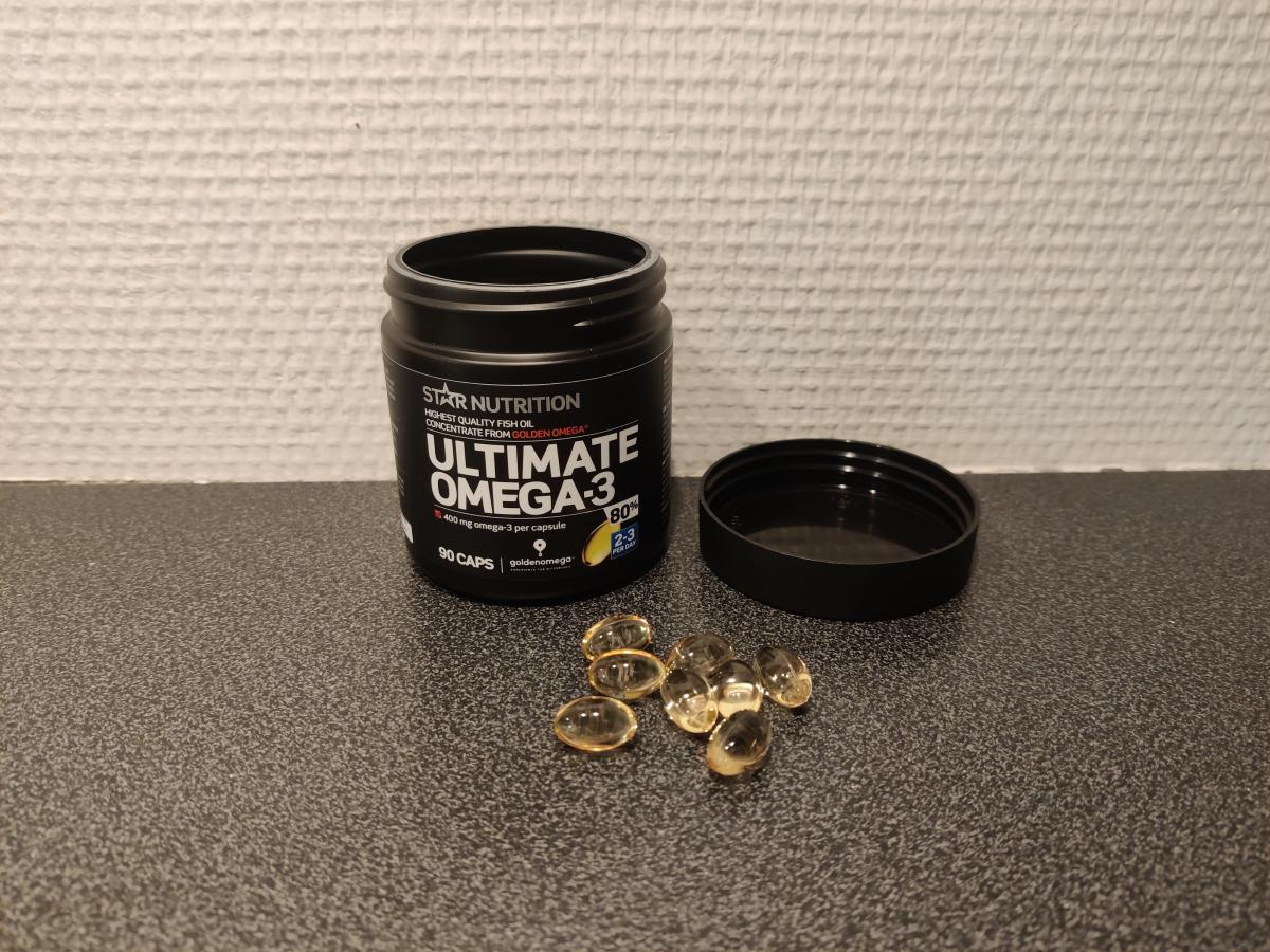 Kapslar bredvid burken på köksbänken under vårt test av Ultimate Omega-3 80 procent