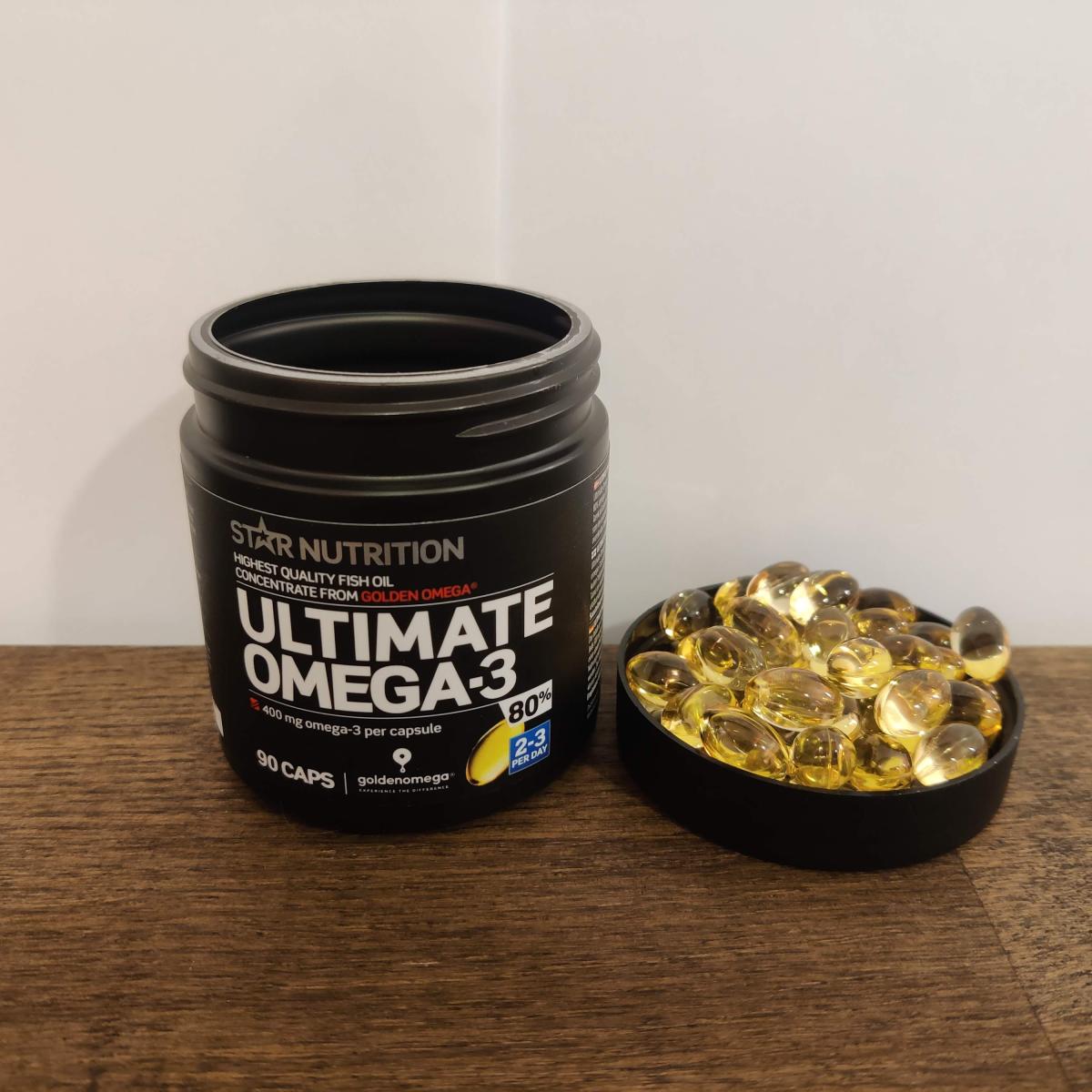 Kapslar bredvid burken på köksbänken under vårt test av Ultimate Omega-3 80 procent