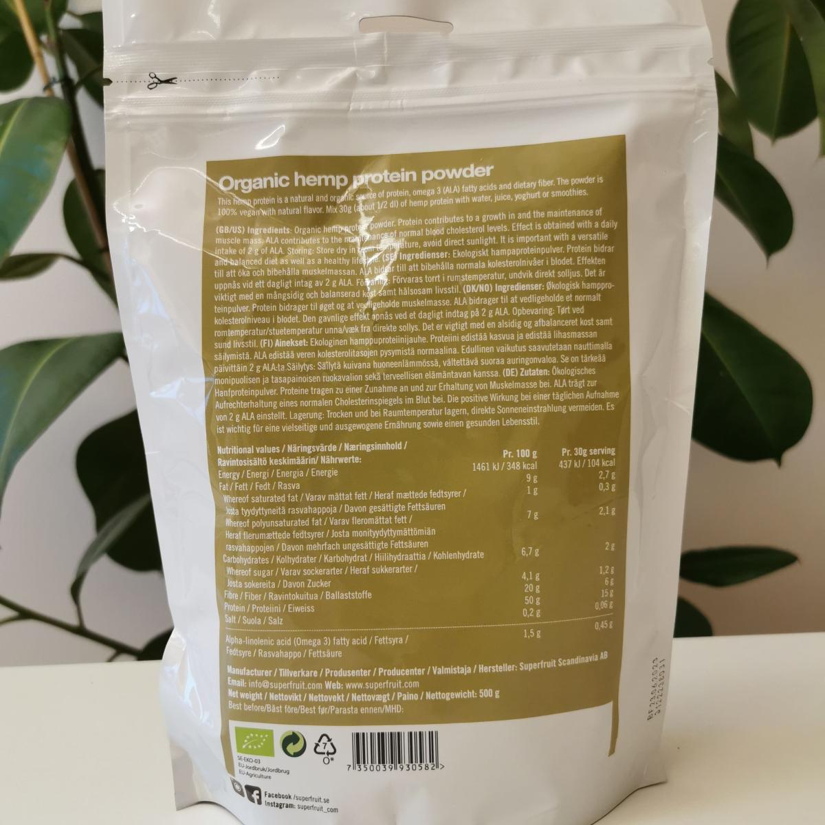 Superfruit Hampaprotein baksida mot ljus bakgrund med växt fotograferad av oss