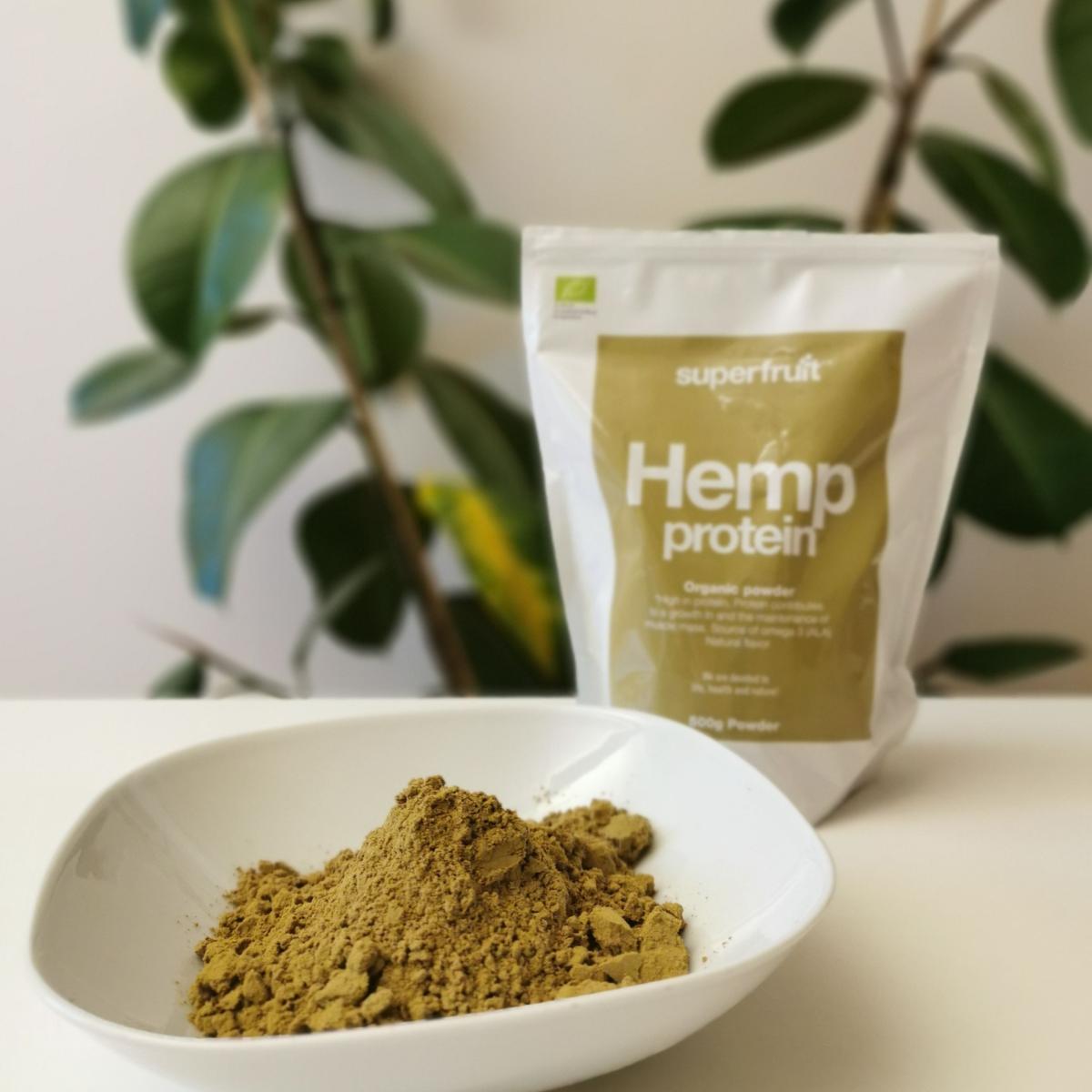 Hampaproteinpulver i skål med Superfruit-påsen i bakgrunden fotograferad av oss under testet
