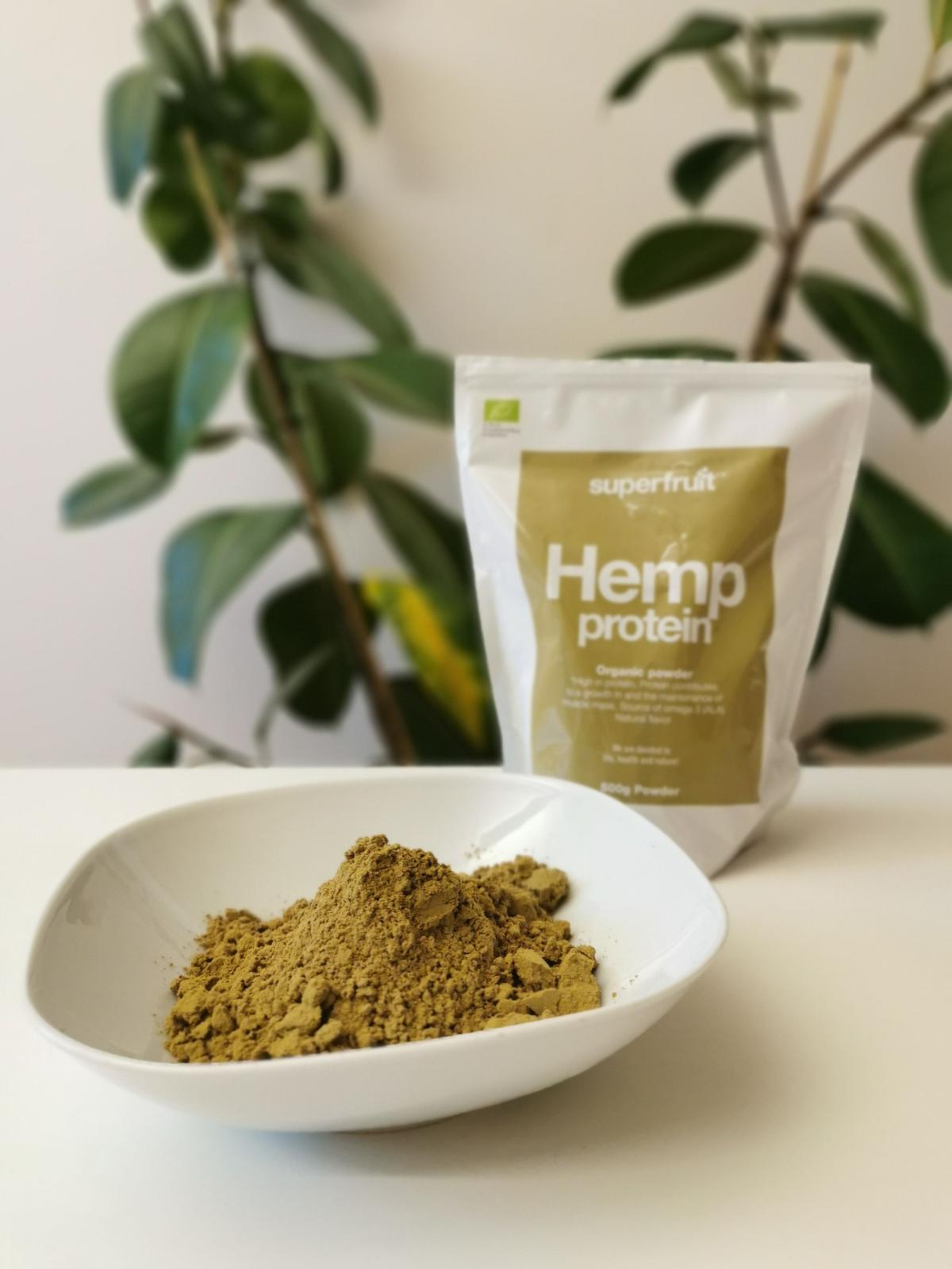 Hampaproteinpulver i skål med Superfruit-påsen i bakgrunden fotograferad av oss under testet