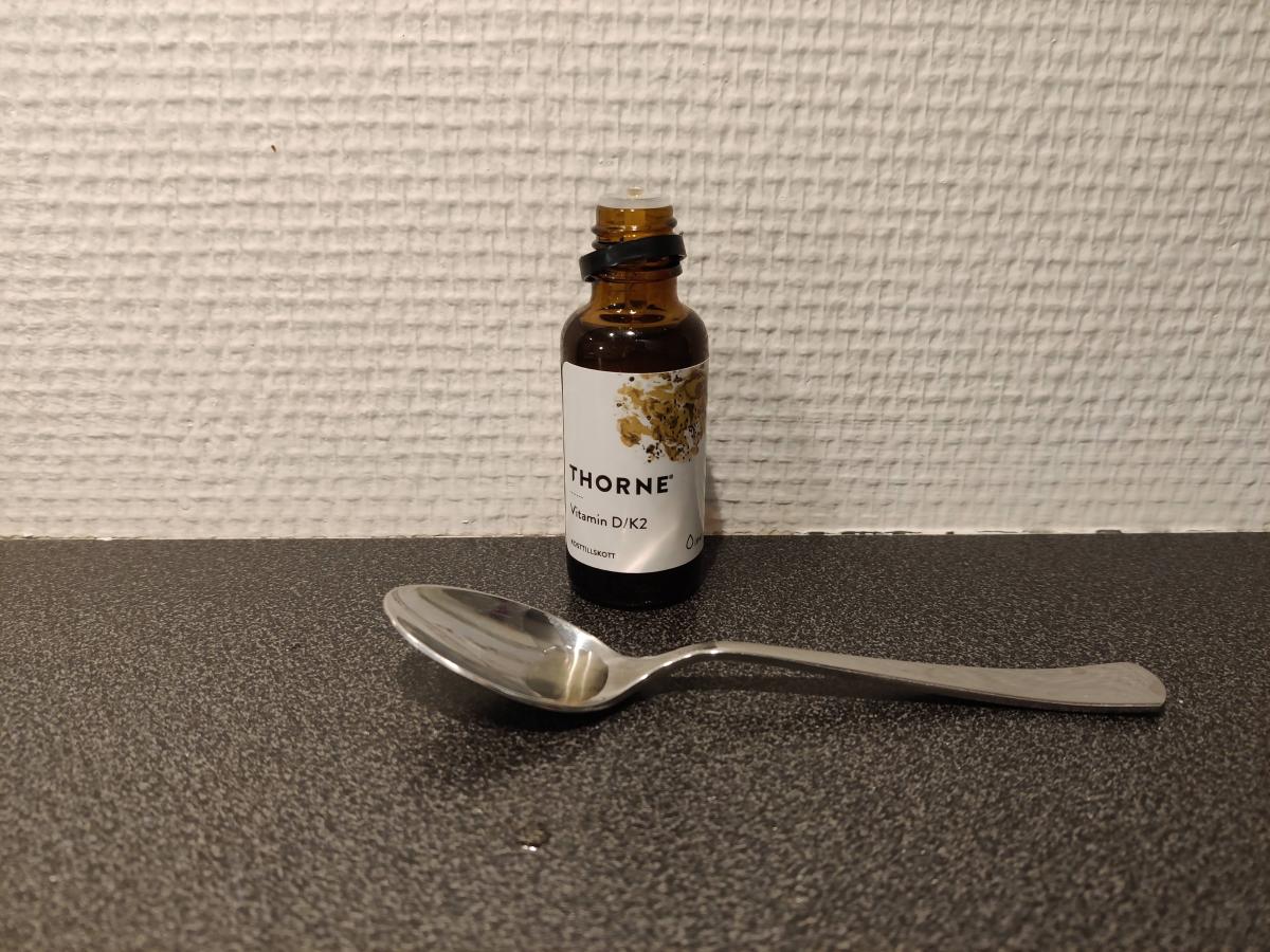 Thorne Vitamin D K2 droppflaska med sked på bänk foto från vårt test